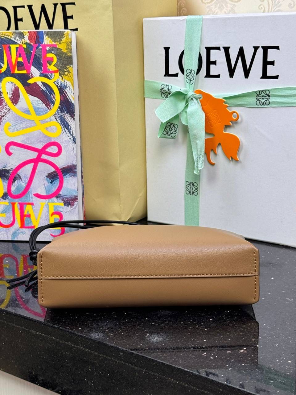 🎈𝘒𝘯𝘰𝘵 𝘛手拿包👜 —【橡木棕/黑色到货✅】 编码：522414 尺寸：𝟐𝟐.𝟓-𝟓.𝟓-𝟏𝟓.𝟓𝐜𝐦 全新撞色绳结拉链头和腕带设计，顶部拉链开合，内部人字纹帆布衬里以及2个皮隔层卡位，正面饰以品牌标志性烫金𝗟𝗼𝗴𝗼，方便时尚多用。