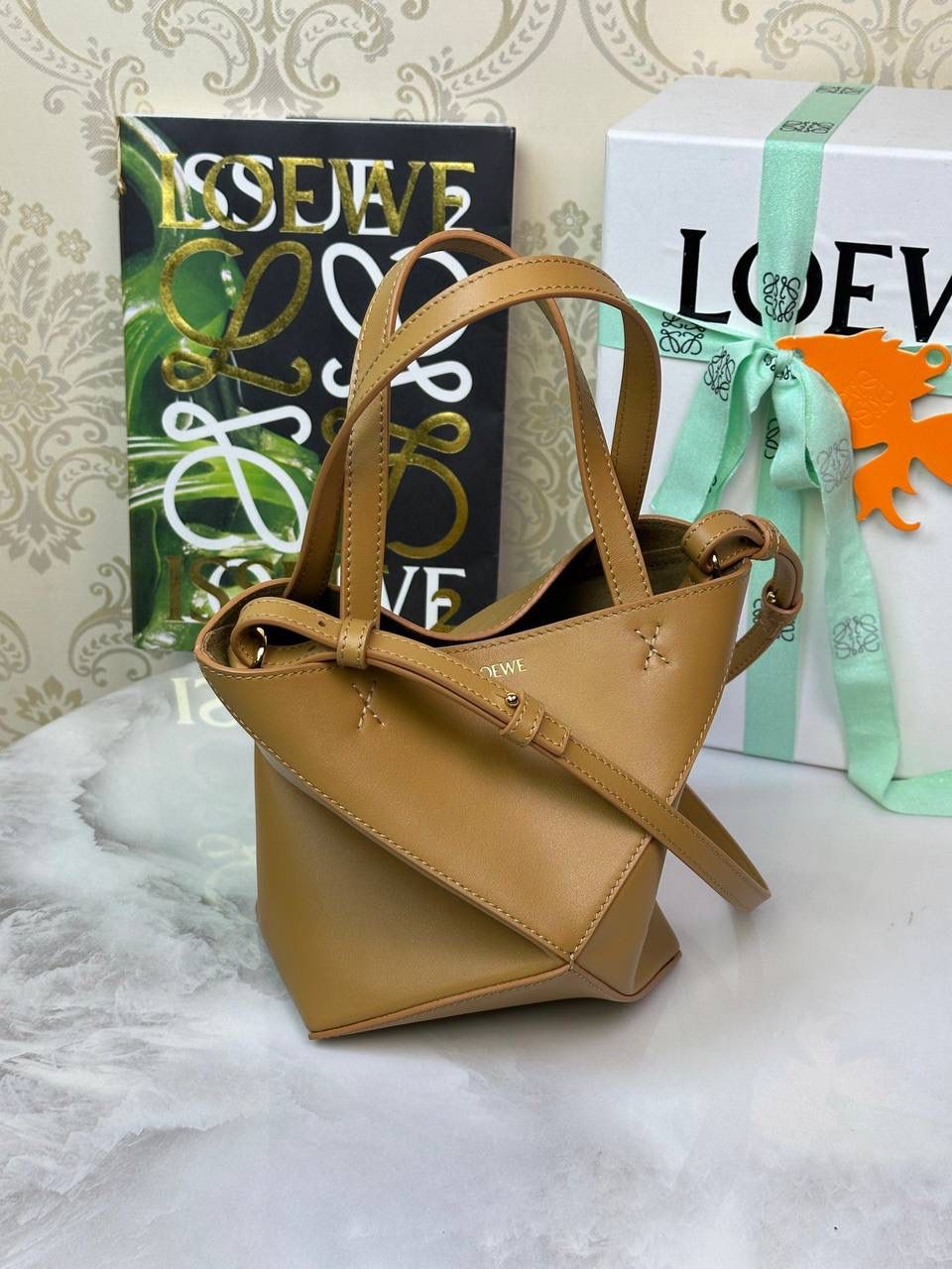 *𝐌𝐢𝐧𝐢 𝐏𝐮𝐳𝐳𝐥𝐞 𝐅𝐨𝐥𝐝折叠手袋👜* ——全新【𝗡𝗘𝗪】升级‼️ 延续经典𝙋𝙪𝙯𝙯𝙡𝙚的标志性几何裁剪设计，新晋顶流🅰️𝙋𝙪𝙯𝙯𝙡𝙚 𝙁𝙤𝙡𝙚 𝙏𝙤𝙩𝙚以折纸包为灵感，升级成🉑完全折叠‼️的结构，立体与平面任意切换，出差旅行🧳必备单品。小牛皮材质轻且柔软，𝐌𝐢𝐧𝐢尺寸搭配一条可拆卸式肩带，手提，肩背，斜挎多样化背法✨ 尺寸：𝟏𝟔.𝟓-𝟗.𝟓-𝟐𝟎cm 款号：052322