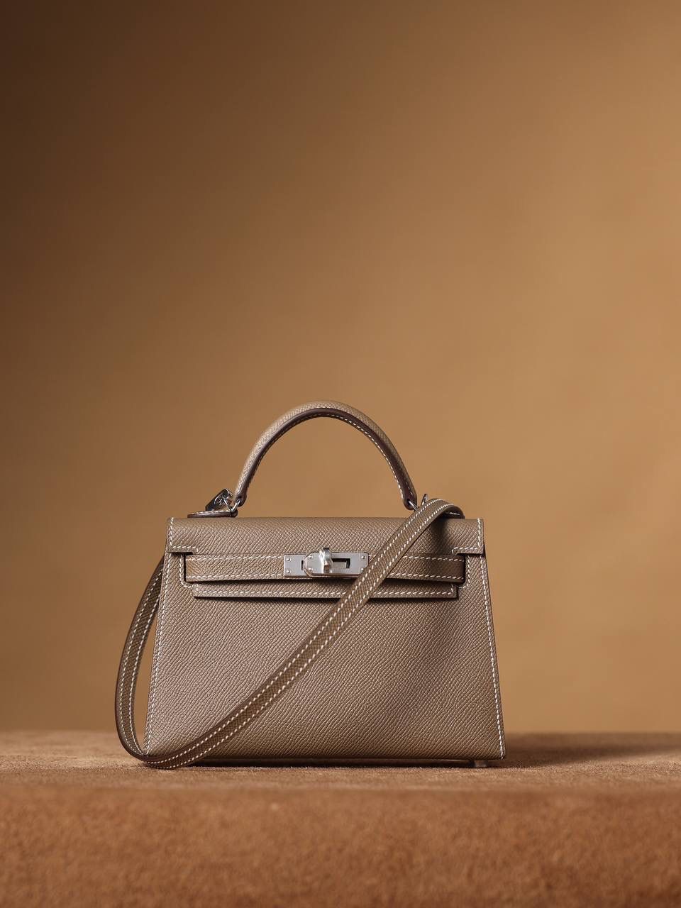 HERMES 爱马仕 Mini Kelly 二代 👜✨ Mini Kelly 二代 大象灰银扣 高清实拍图 尺寸：19*12*6cm Hermès爱马仕是世界著名的奢侈品品牌，1837年由Thierry Hermès创立于法国巴黎。爱马仕早年以制造高级马具起家，迄今已有180年的悠久历史。 其整个品牌从整体到细节以及专卖店，都弥漫着浓郁的以马文化为中心的深厚底蕴🎀