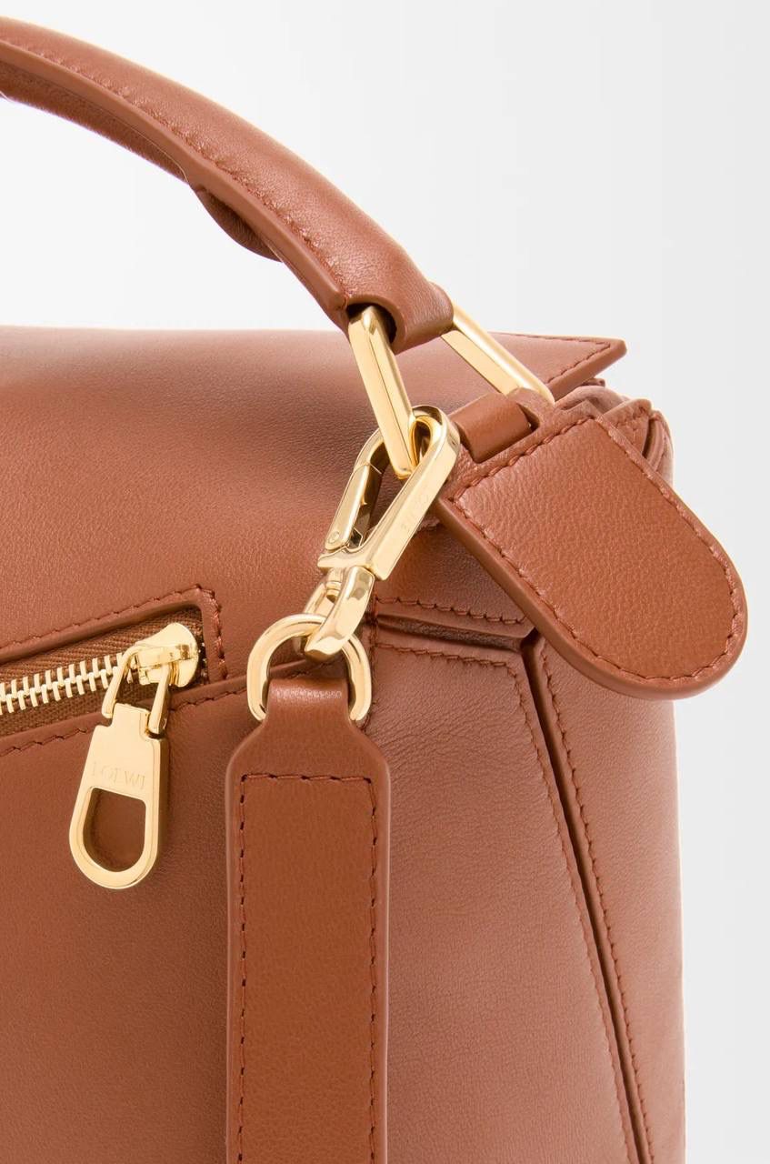 【十周年限定款🆚经典款】 👉🏻区别1️⃣：里外全羊皮，侧面增加可拆卸标牌挂饰以及气球骰子，内里更换为金标（如图1️⃣2️⃣3️⃣4️⃣） 👉🏻区别2️⃣：底部增加脚钉保护整个包包，以前只有中号以上才有（如图5️⃣） 👉🏻区别3️⃣：铰链式拉链头，拉牌刻有品牌创建年份以及品牌英文LOGO（如图6️⃣7️⃣） 👉🏻区别4️⃣：肩带调节变更为针扣调节（如图8️⃣）