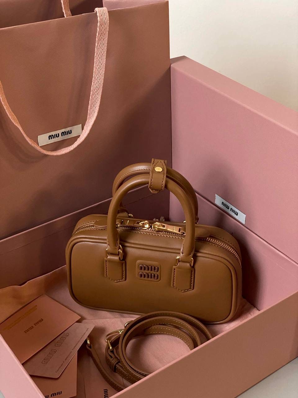 🈶干邑色，迷你 𝗠𝗶𝘂𝗠𝗶𝘂保龄球，大爆款 新尺寸也太可爱了！ 喜欢小包的姐妹这只必买！它要比小号小一些也窄一些 就巴掌大小，但容量还挺大的 装俩部手机都绰绰有余，日常够用 肩带长短也很ok，手拎斜挎都好看 反正放心冲就是了！拥有它，上班牛马的心情都会被治愈～ 迷你：19×10×5cm #F0011m 小号：22x10.5x7.5cm 大号：27x12x9cm