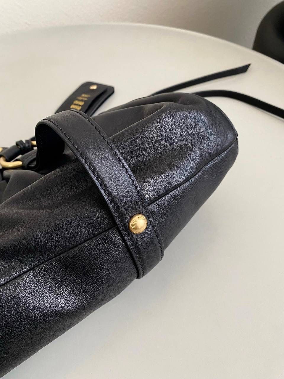 🈶黑色 𝗠𝗶𝘂𝗠𝗶𝘂 𝗡𝗮𝗽𝗽𝗮 饺子包 这只亮点在于包口用的是抽绳束口！ 抽绳可以随意调节，搭配的纤长双手柄可肩背或手提也可以随意捧在腰际'柔软的皮质加上不定型的设计，慵懒随性的调调一下就出来了 满满的vintgge复古感，既叛逆又不失格调'好喜欢啊 16×44×10.5cm #F0016m