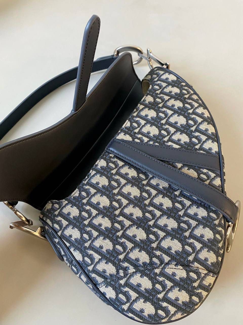 🈶老花配皮，大号 𝗖𝗗 𝗦𝗮𝗱𝗱𝗹𝗲 经典马鞍包 王者中的王者，地位不可撼动 席卷了整个时尚圈今年依旧火爆啊 也让最新出的银扣+黑篮牛皮翻盖版 再次把热度推向巅峰！真的太酷了 时尚感拉满的同时增添了一份完美女性的力量感！ 25.5×20×6.5cm #8006m