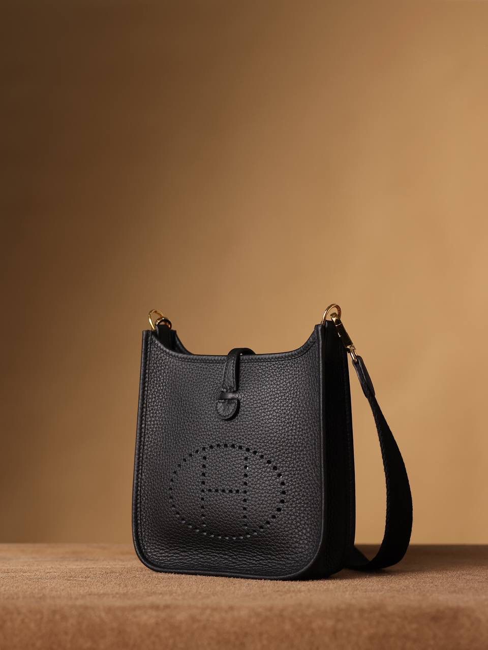 HERMES爱马仕Evelyne 16伊芙琳黑色金扣👜✨ TaurillonMaurice 小公牛皮 尺寸：16*18*5cm 爱马仕Evelyne伊芙琳 Evelyne包的设计灵感来自于一种名为“马鞍袋”的马具袋，这是一种常用于骑手和马车夫的袋子，用于储存和运输马具和其他必需品。 爱马仕将这种马具袋的经典元素与品牌的手工艺传统相结合，打造出了具有时尚感和功能性的包包。 因此，伊芙琳包不仅是一款实用的手提包，同时也代表着品牌深厚的历史和文化传统❤️