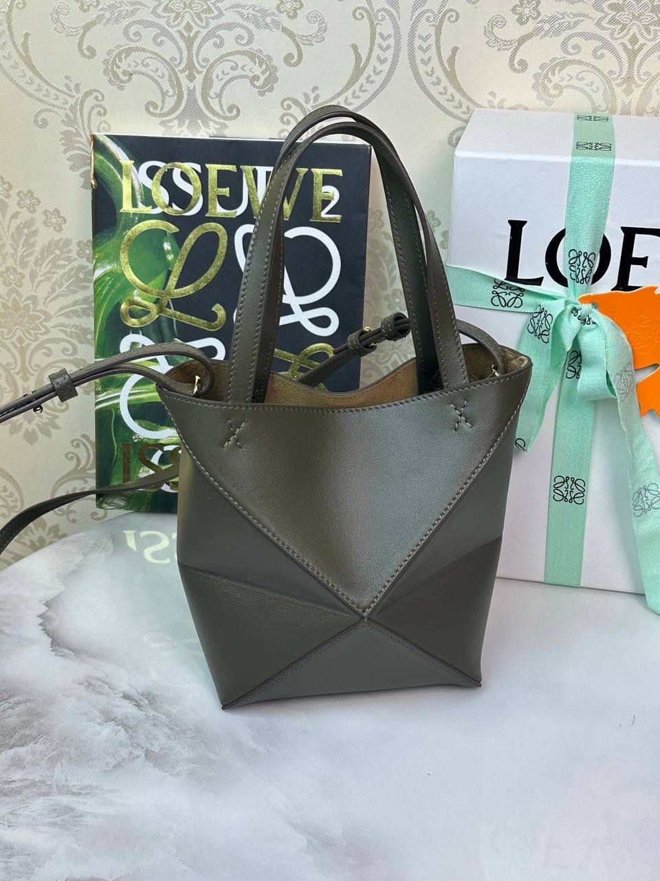 *𝐏𝐮𝐳𝐳𝐥𝐞 𝐅𝐨𝐥𝐝折叠手袋👜* ——全新【𝗡𝗘𝗪】升级‼️ 延续经典𝙋𝙪𝙯𝙯𝙡𝙚的标志性几何裁剪设计，新晋顶流🅰️𝙋𝙪𝙯𝙯𝙡𝙚 𝙁𝙤𝙡𝙚 𝙏𝙤𝙩𝙚以折纸包为灵感，升级成🉑完全折叠‼️的结构，立体与平面任意切换，出差旅行🧳必备单品。小牛皮材质轻且柔软，𝐌𝐢𝐧𝐢尺寸搭配一条可拆卸式肩带，手提，肩背，斜挎多样化背法✨ 尺寸：𝟏𝟔.𝟓-𝟗.𝟓-𝟐𝟎cm 款号：052322