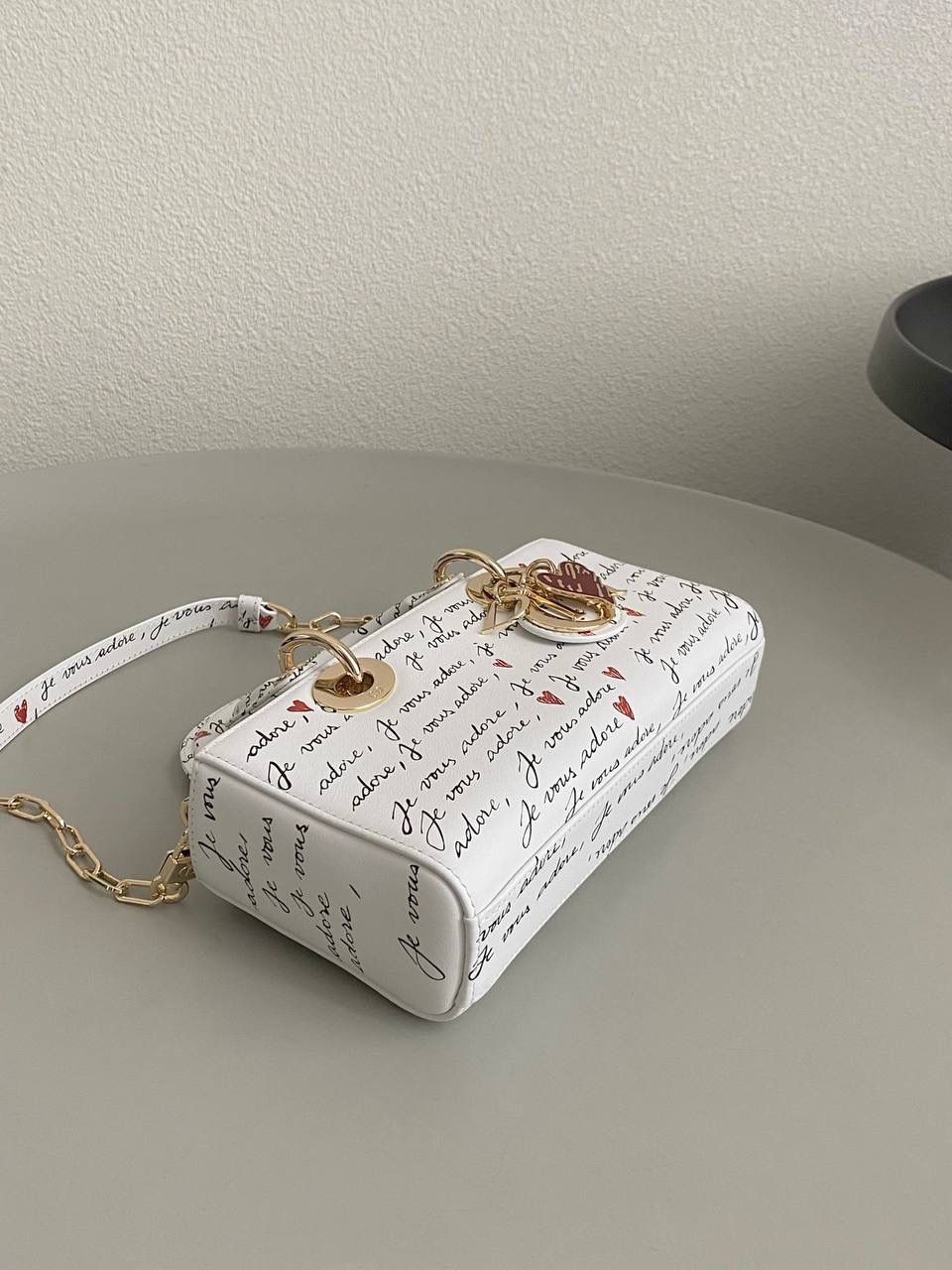 爱心白🎀𝗗𝗜𝗢𝗥 𝗗-𝗝𝗼𝘆小号 七夕限定，更是每一天的爱意限定 情书💌款这种淡淡的色调好梦幻 从印花到纯色都散发着治愈的气息 刻印的纹理感，伸手可触 连绵不断的法语我爱你'点缀着爱心❤️ 是写满了法式浪漫的包包呀！ 请拥有，这独一份的爱意 22×12×6cm