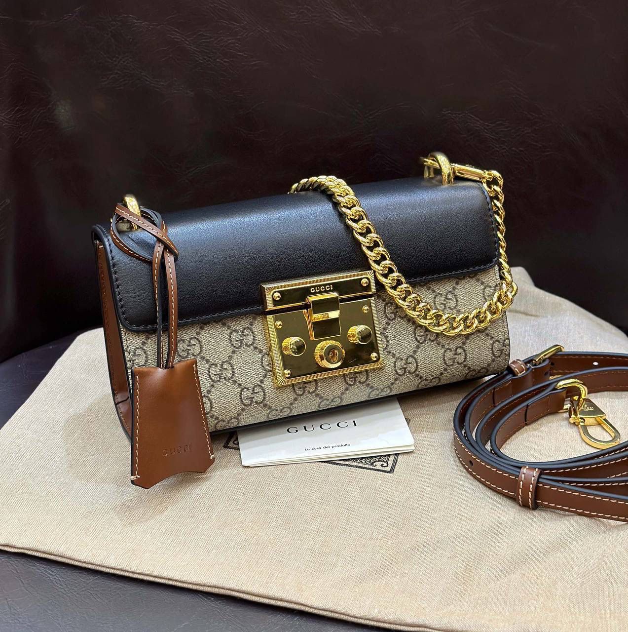 🔥𝐏𝐚𝐝𝐥𝐨𝐜𝐤 月光宝盒# ▫型号：735103 ▫️尺寸：22*11.5*7.5cm 👑经典之王𝙥𝙖𝙙𝙡𝙤𝙘𝙠又出新成员啦，标志性的小锁扣作为主打，保留了原样貌的设计‼️采用原厂黑棕牛皮➕G花面料 三合一的色彩尽显小女人气质的一款包。横版内存空间更大、各自好用、单肩/手挽/斜挎等。钢制耐磨五金，细节都源于正板打造。非常减龄哦！容量也足够日常外出必备小物件！788590