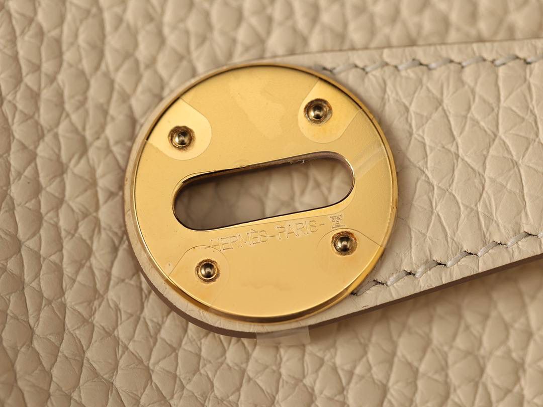 Hermes 爱马仕 Lindy 26cm 奶油白金扣👜✨ 尺寸：26*18*14 cm 奶油白真的实物很漂亮，YYDS😍 五金介绍，拉链尾部的"H"是刚好的正方形，而且每笔都是很直，菱角分明，表明平整 图二至六图的的五金四个小螺丝是人工围着这四个小圆点边雕琢上去的，而且小螺丝这点的周围圈是有孤独深的圆形，这点很多人都不知道，这个是符合正品工艺的 拉链是纯原装金扣的RIRI拉链 所以在五金方面我们拿捏的死死的 无人能敌 🤟🏻 渠道货是注重任何一个细节的 做到任何人都做不到的点 这就是天花板😍💯👍