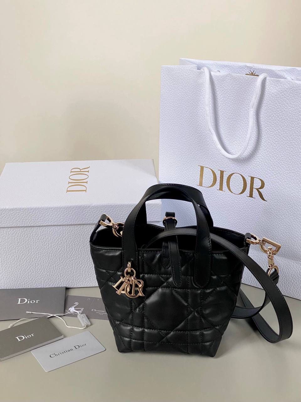 🈶黑色，迷你 𝗗𝗜𝗢𝗥 𝗧𝗼𝘂𝗷𝗼𝘂𝗿𝘀新版竖款 火爆全网toujours缩小版来啦！ 看到真的心动得不行～ 实物就是常规迷你水桶大小， 真的可爱死 别说，包虽小但容量还挺大的 日常用品都能轻松装上 肩带长度也刚刚好，不挑身高 反正就是太乖啦！夏日必备 😍 迷你：13×15×12cm #M1272m 中号：20x22x18.5cm 小号：16x18x12cm