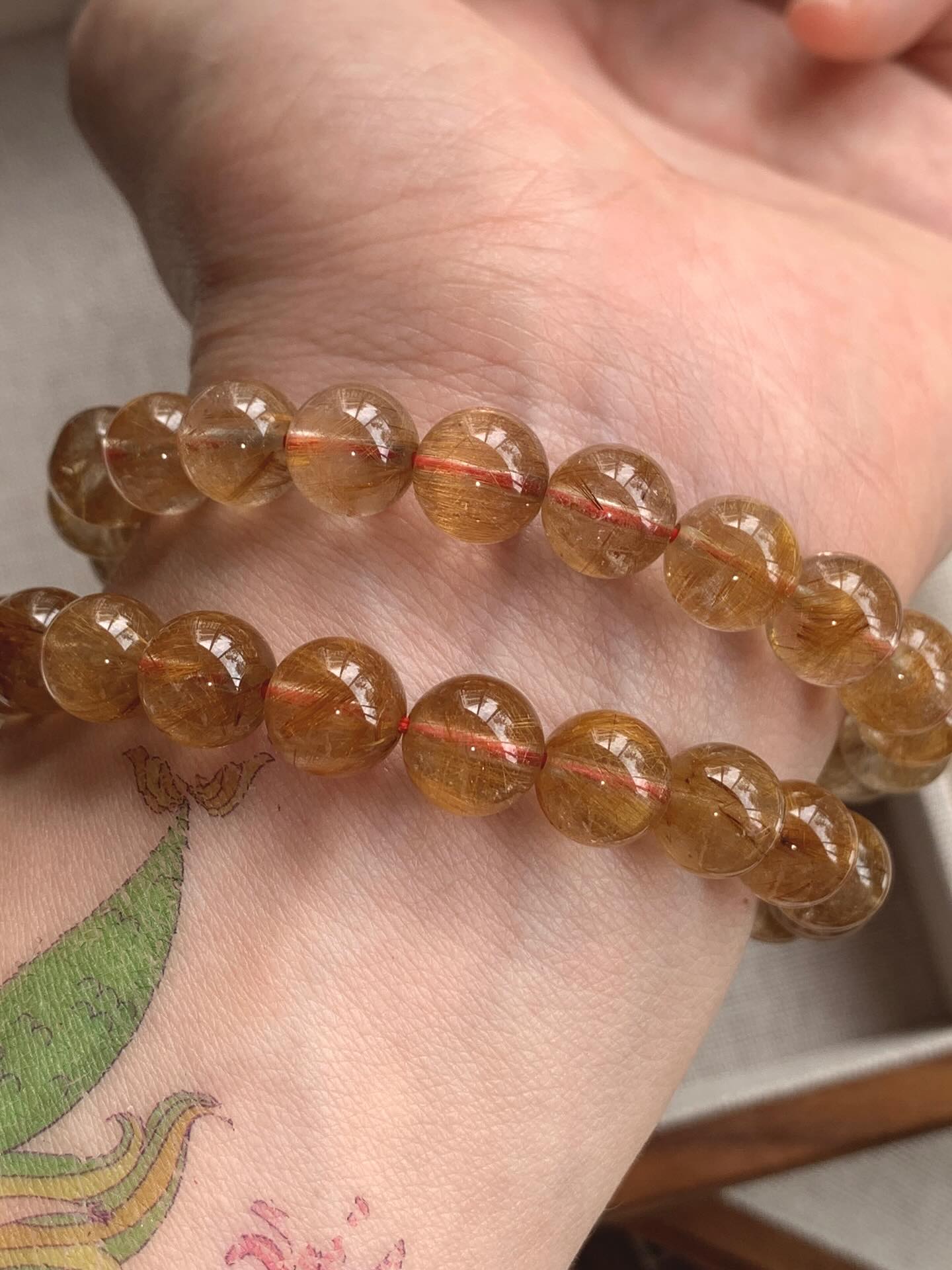 高货咖啡金发晶 ｜High Grade Gold Rutile 9.1/9.3mm RM218 金发晶被认为具有强大的财富能量，可以增强事业运和财运，同时也能提升自信、勇气和果断力。此外，它还能帮助稳定能量场、辟邪化煞、增进人际关系，并对身体健康有益，特别能帮助消化系统和提升活力Gold rutile quartz is believed to boost awareness, creativity, and confidence while also acting as an energy amplifier for other crystals. It helps to balance emotions, ease loneliness and depression, and promotes forgiveness. This crystal is also considered a powerful aid for manifestation, helping to ground divine energy and activate creative inspiration. #金发晶 #goldrutile #天然水晶 #水晶手串 #马来西亚水晶网店 #gemstone #naturestone