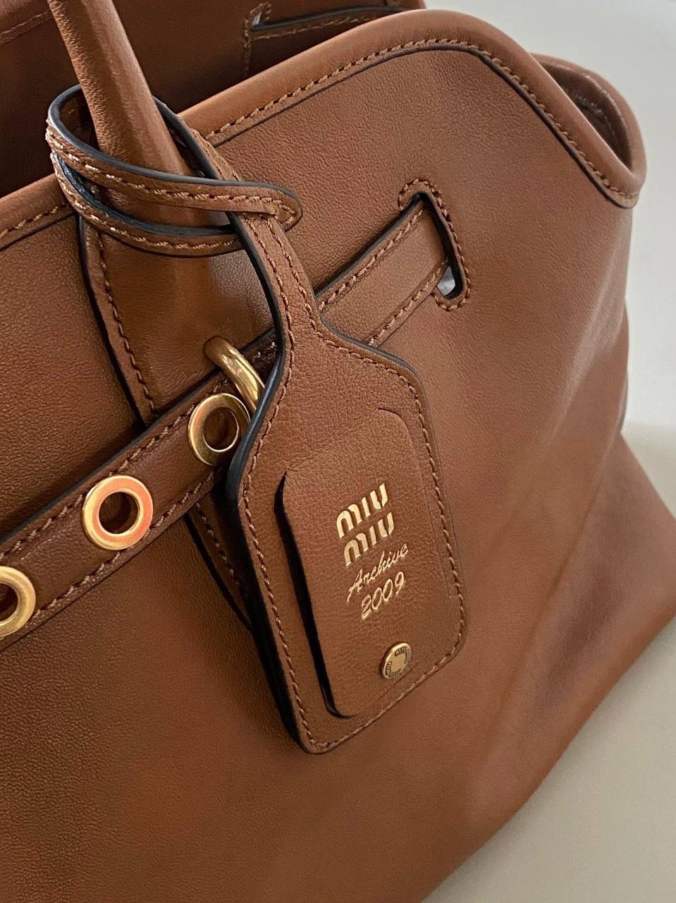 🈶焦糖色， 𝗠𝗶𝘂𝗠𝗶𝘂 手提包·横版 这只Aventure我要夸爆它！ 绝对是公文包中的颜值天花板 这款有多难买不用多说，绝对的断货王 酷酷的慵懒感洋气且时髦 还有一丢vintage感，超有调 上班通勤，日常出街都超出片 22.5×44×14.5cm #F0023m