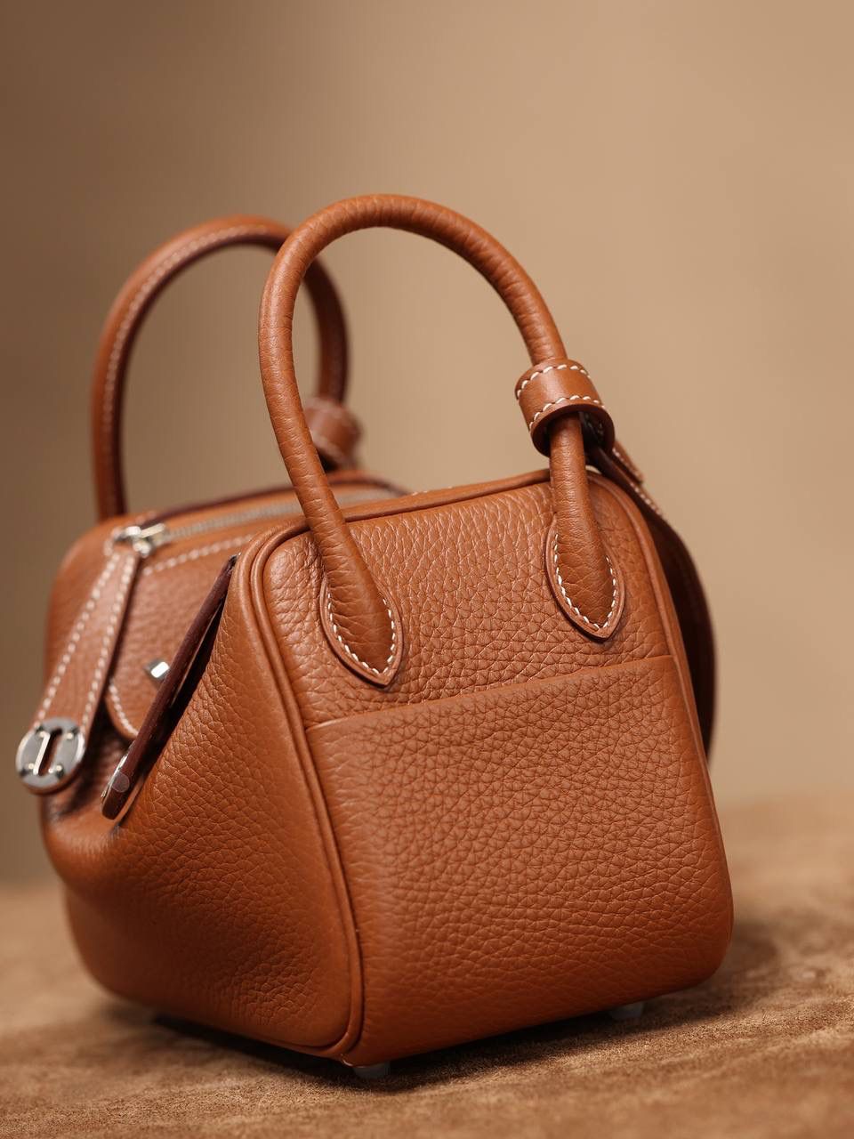 Hermes 爱马仕 Lindy Mini 19cm 金棕色银扣👜✨ Lindy 独家渠道货 独家欧洲原厂皮原厂五金组装的ZP尾单货 尺寸：19*12.5*9cm Lindy是采用原厂的正品TC皮，什么是TC皮？ 爱马仕专用的clemence,简称tc皮，是Hermes最受欢迎的皮革之一，颜色会比Togo少一些，但是纹路比Togo细腻，含油更高，更软，因此稍稍有些下垂感的特点。