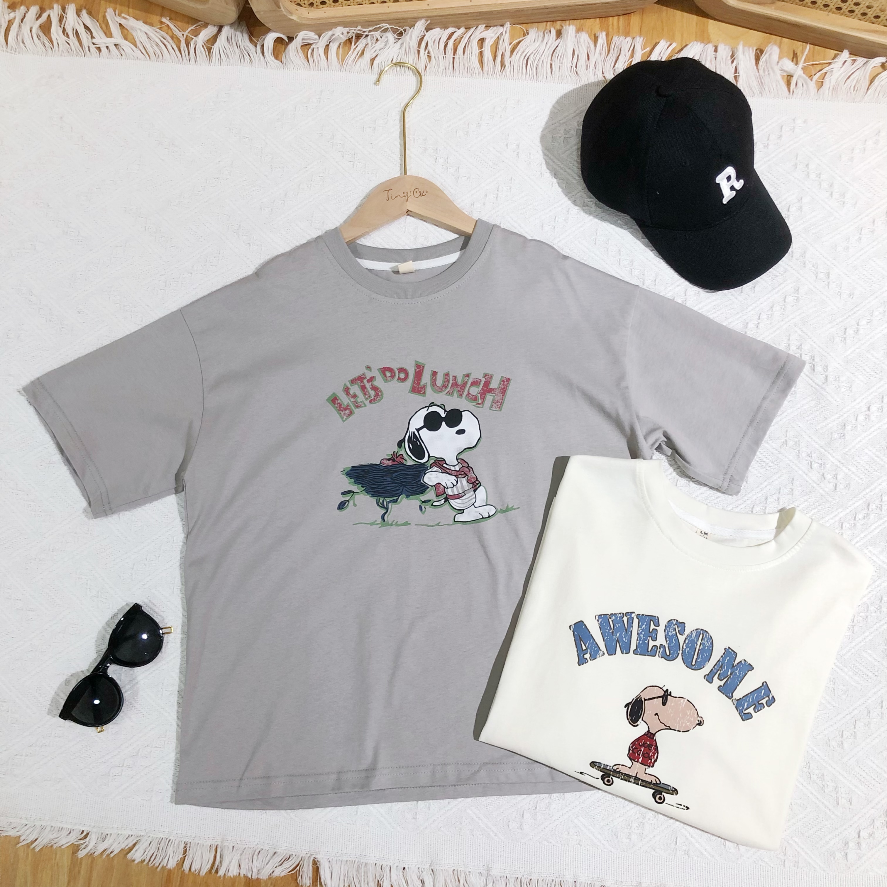 Here are a few possible product titles for the image:**Short & Sweet:***   Snoopy T-Shirts*   Graphic T-Shirts**More Descriptive:***   Snoopy Let's Do Lunch Graphic Tee and Snoopy Awesome Skateboard Tee*   Vintage Snoopy T-Shirt Collection*   Snoopy Character T-Shirt Set**Catchy/Trendy:***   Snoopy Chill Vibes Tee Collection*   Snoopy Retro Cartoon Graphic T-Shirt 