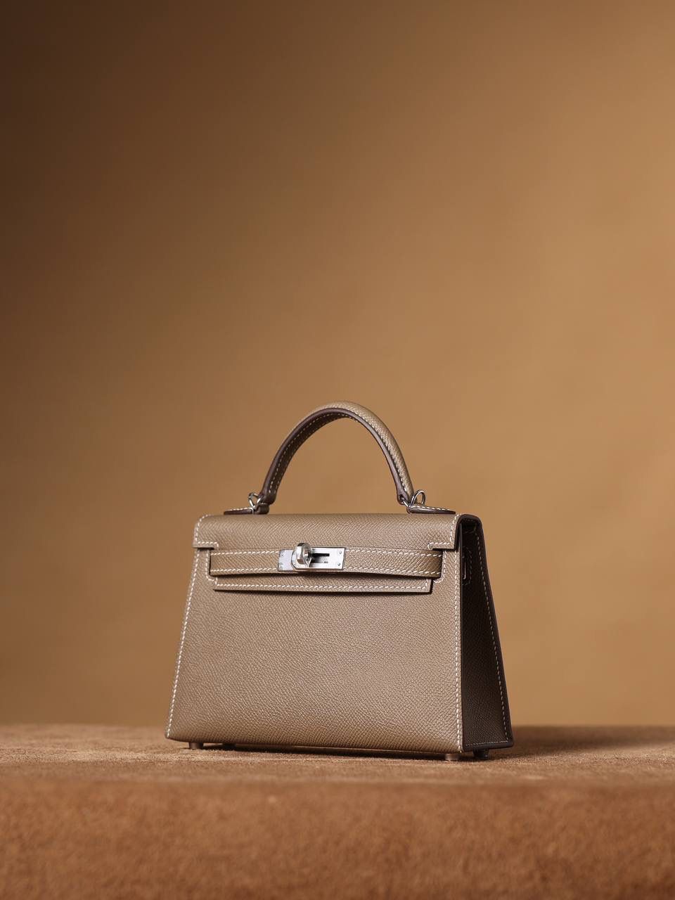 HERMES 爱马仕 Mini Kelly 二代 👜✨ Mini Kelly 二代 大象灰银扣 高清实拍图 尺寸：19*12*6cm Hermès爱马仕是世界著名的奢侈品品牌，1837年由Thierry Hermès创立于法国巴黎。爱马仕早年以制造高级马具起家，迄今已有180年的悠久历史。 其整个品牌从整体到细节以及专卖店，都弥漫着浓郁的以马文化为中心的深厚底蕴🎀