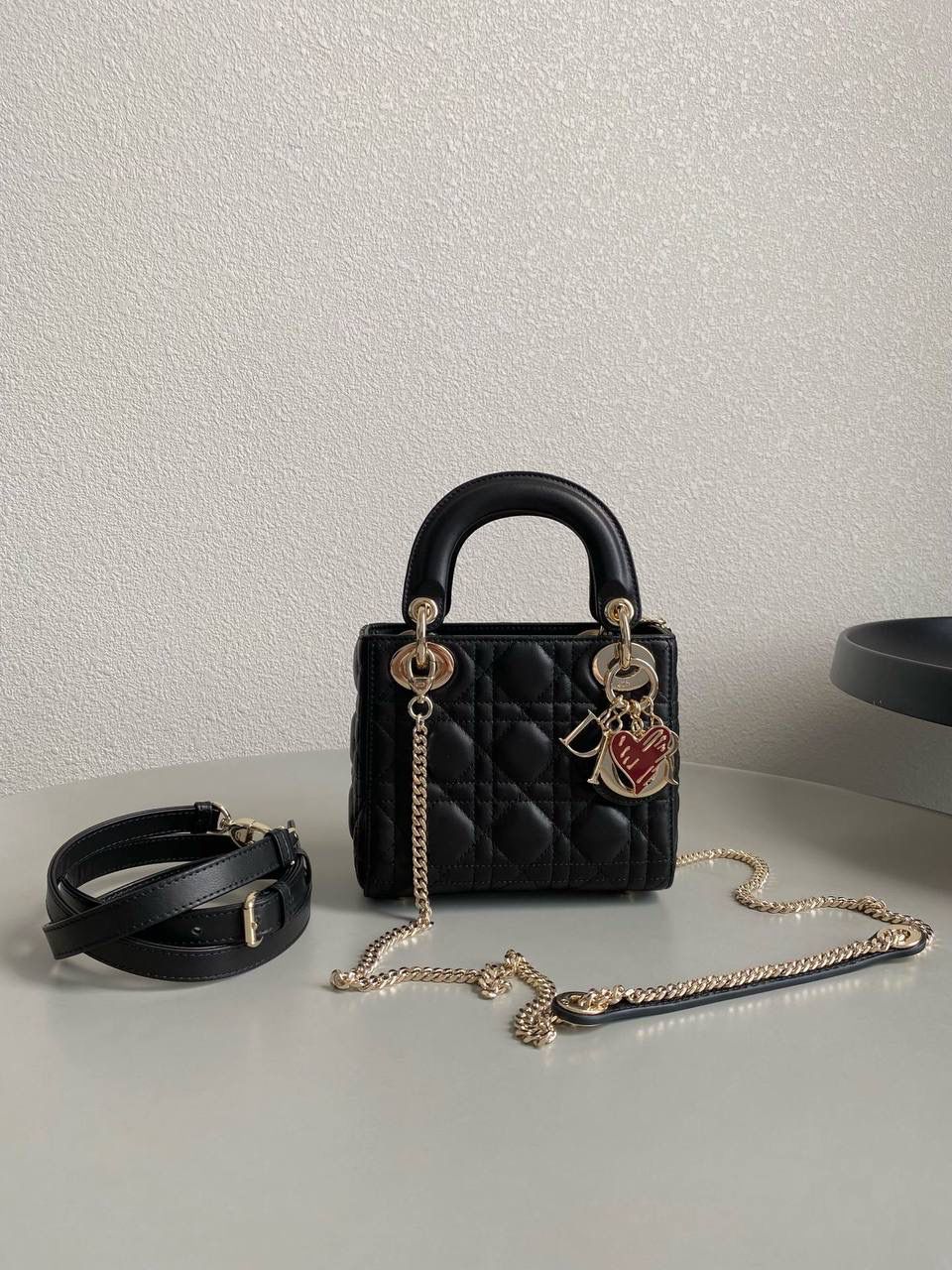 黑色 🖤 三格 𝗗𝗜𝗢𝗥 𝗟𝗮𝗱𝘆七夕限定 在经典的基础上加了爱心小挂饰 让整个氛围有了爱的烂漫气息 戴妃作为经典的代表，怎么买怎么对 特别手拎时会显得整个人非常温柔优雅 我一直都推荐女生一定要有一只经典款 每个颜色都好好看，完全不需太纠结❤️‍🔥 17×15×7cm