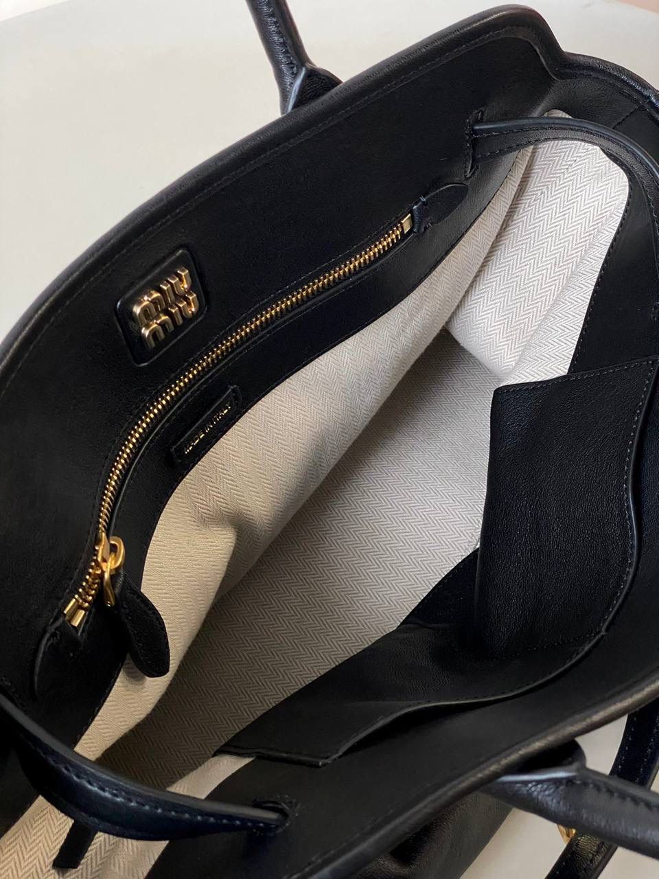 🈶黑色 𝗠𝗶𝘂𝗠𝗶𝘂 手提包 这只Aventure我要夸爆它！ 绝对是公文包中的颜值天花板 这款有多难买不用多说，绝对的断货王 酷酷的慵懒感洋气且时髦 还有一丢vintage感，超有调 上班通勤，日常出街都超出片 很有年轻人的活力！ 31×40×13cm #F0023m