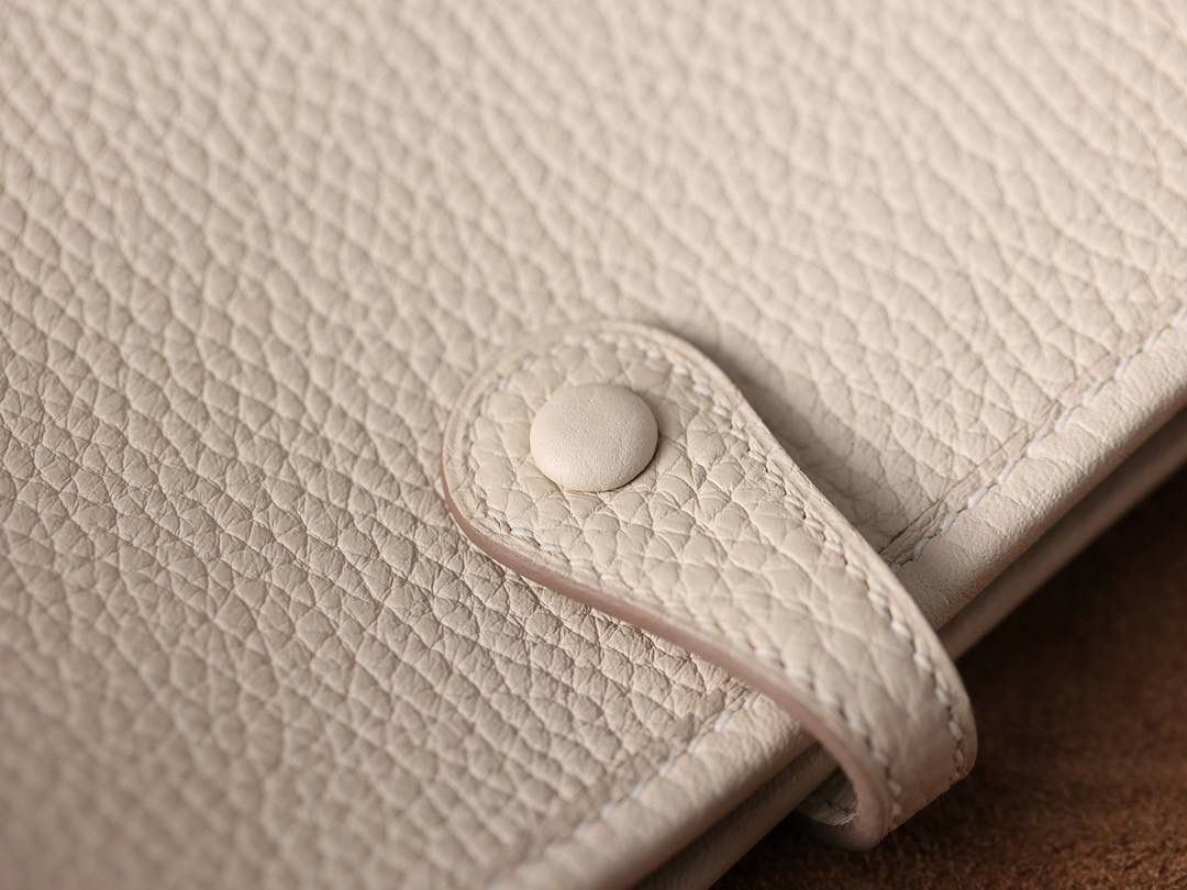 HERMES爱马仕Evelyne 16伊芙琳奶昔白金扣👜✨ TaurillonMaurice 小公牛皮 尺寸：16*18*5cm 爱马仕Evelyne伊芙琳 Evelyne包的设计灵感来自于一种名为“马鞍袋”的马具袋，这是一种常用于骑手和马车夫的袋子，用于储存和运输马具和其他必需品。 爱马仕将这种马具袋的经典元素与品牌的手工艺传统相结合，打造出了具有时尚感和功能性的包包。 因此，伊芙琳包不仅是一款实用的手提包，同时也代表着品牌深厚的历史和文化传统❤️