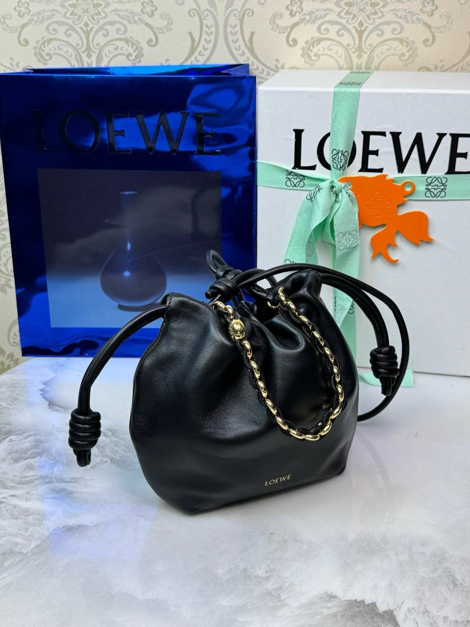 🎈迷你链条款𝙁𝙡𝙖𝙢𝙚𝙣𝙘𝙤 𝙋𝙪𝙧𝙨𝙚羊皮 ——【黑色】 尺寸：𝟐𝟑.𝟓-𝟓-𝟏𝟕𝐜𝐦 编码：062347 👉🏻延续福袋收缩绳褶皱设计，羊皮包身手感细腻柔软❤️ 👉🏻链条肩带➕皮肩带的双肩带设计，时尚百搭，给足了集美们多样化的选择。肩带可拆卸可调节，磁扣开合，正面烫金𝙇𝙤𝙜𝙤，呈现出高贵典雅的视觉感😍 👉🏻独家背景➕独家品质➕独家全套砖柜礼盒套装，市场高端品质皆在我手✌🏻