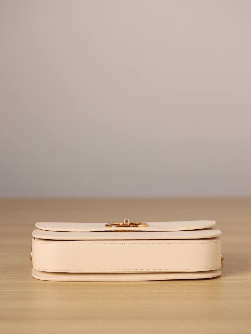 30 MONTAIGNE AVENUE 手袋 灰象牙色光面牛皮革👜✨ 独家渠道货 独家蒙田腋下包白色珐琅扣 尺寸：22.5 x 12.5 x 6.5 厘米 这款 30 Montaigne Avenue 手袋采用典雅的设计，提升此经典系列的格调。 采用黑色光面牛皮革精心制作，圆角翻盖曲线精致，饰以复古金色饰面金属 CD 扣环，灵感源自 Christian Dior 香水瓶的封口。 背面饰以压花 30 Montaigne 标志，搭配由金色饰面金属和与皮革同色调的珐琅链环交替组成的经典链条。 褶层设计，空间宽敞，廓形精致，可手提，肩背或斜挎。