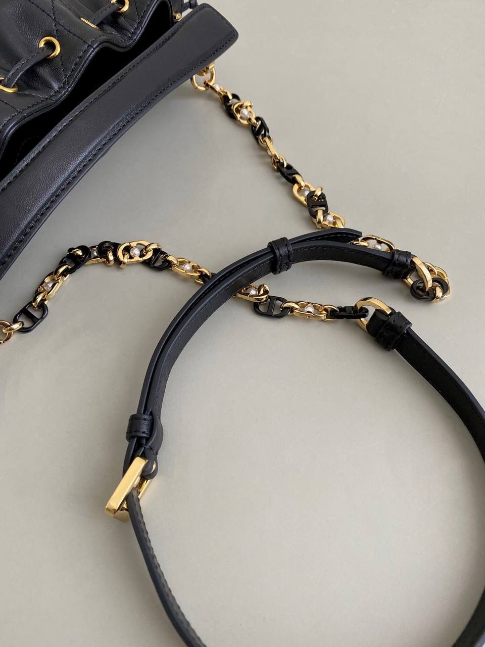 🈶黑色，迷你 𝗗𝗜𝗢𝗥 𝗠𝗮𝗿𝗹𝗲𝗺𝗮水桶包 水桶包好的一点就是容量巨大！ D家新出的这只你不要看它小， 容量我真的超爱～ 风格依然是Jolie同系列的珍珠元素 极简的包身加拼色链条，精致耐看 经典藤格纹羊皮，皮质柔软有光泽 主要是实用，斜挎休闲 手拎乖巧精致， 适用于任何场合！ 绝对是你日常出勤率最高的一款 17×16×9cm #7060m