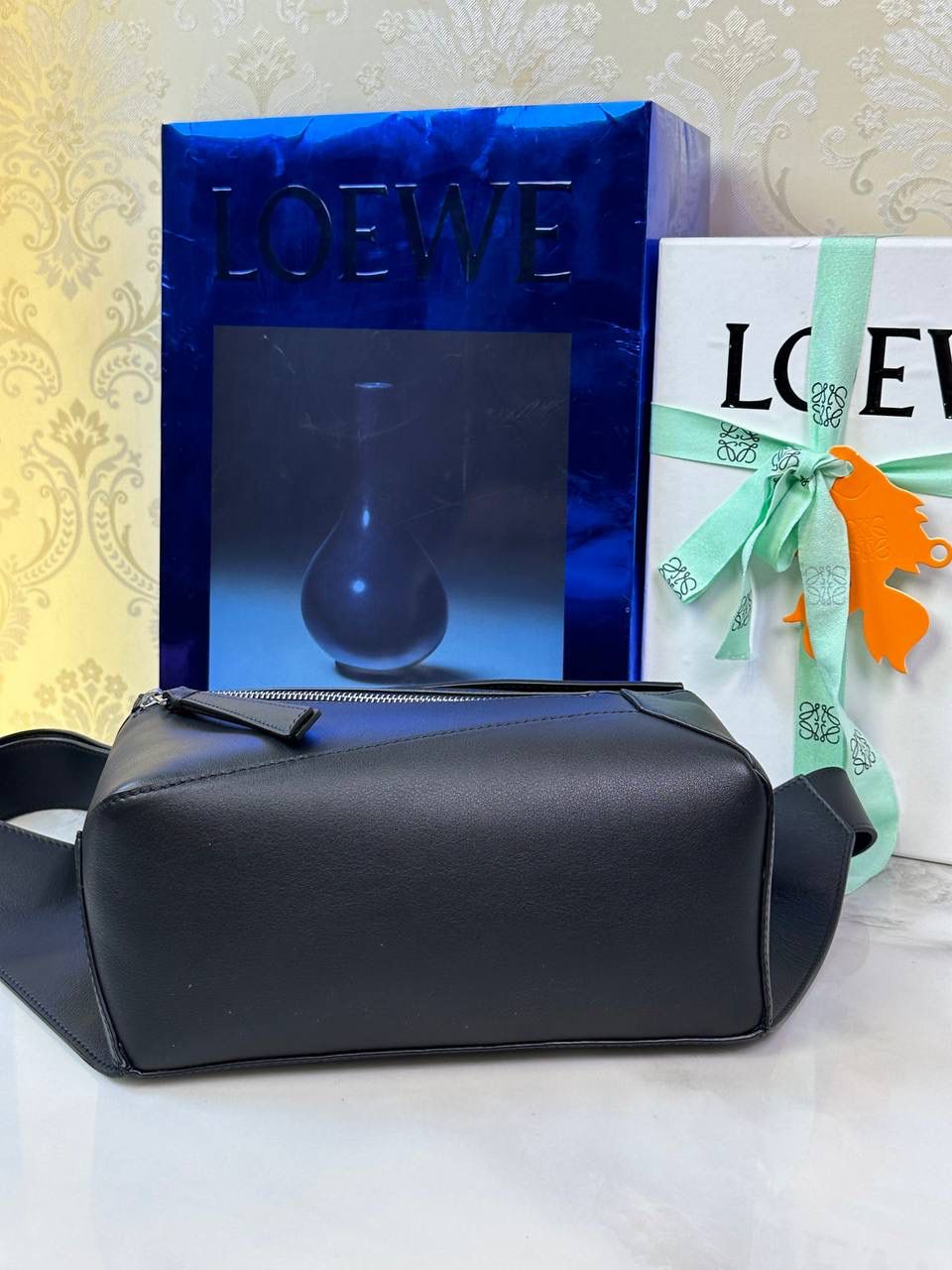 ⭐️最新升级版𝟮.𝟬-𝗣𝘂𝘇𝘇𝗹𝗲腰包⭐️ （黑色 到货‼️） 尺寸：𝟮𝟰-𝟭𝟬.𝟱-𝟭𝟲𝗰𝗺 款号：052343 👉🏻长方体形状和精确的切割技巧创造出Puzzle 腰包以及独特的几何线条成为 “Loe罗家”的著名代表作~ 👉🏻金属搭扣开合，刻有标志logo徽标，可调节肩带，翻盖大容量插袋和一个外部拉链口袋，🐂柔软细腻napa小牛皮，正品Ykk五金，Anagram压纹，人字纹棉麻帆布内里 👉🏻（男女♀♂同款）大小非常合适。胸包、背包、单肩、斜挎 腰包五种背法任你解锁🔒 👉🏻 （独家背景➕独家品质➕独家包装➕独家控制对版细节📦➕精致全套礼盒套装❤️） 重点：让你花最少的钱💰体验最大的仪式感❤️