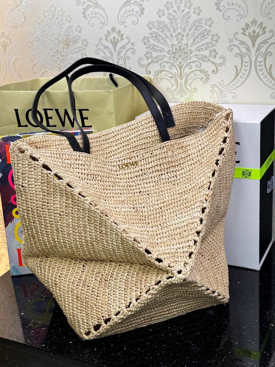 🎈*𝐏𝐮𝐳𝐳𝐥𝐞 𝐅𝐨𝐥𝐝折叠手袋👜*（进口拉菲草） ——全新【𝗡𝗘𝗪】升级‼️ 👉🏻延续经典𝙋𝙪𝙯𝙯𝙡𝙚的标志性几何裁剪设计、新晋顶流🅰️𝙋𝙪𝙯𝙯𝙡𝙚 𝙁𝙤𝙡𝙚 𝙏𝙤𝙩𝙚以折纸包为灵感、升级成🉑完全折叠‼️的结构、立体与平面任意切换、出差旅行🧳必备单品、可肩背或手提、正面饰品牌标志性英文Logo。 👉🏻采用进口拉菲草手工编织而成、该种材料工序复杂、制作成本高昂、但因其柔软度高、环保性能更好、不易变行被广泛应用。 尺寸：𝟐𝟓.𝟓-𝟏𝟒.𝟓-𝟑𝟏.𝟓cm 款号：052316