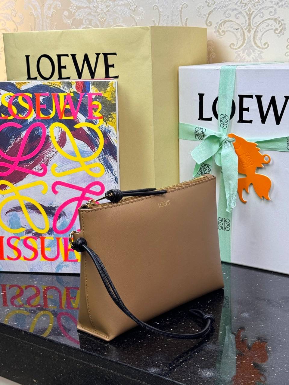 🎈𝘒𝘯𝘰𝘵 𝘛手拿包👜 —【橡木棕/黑色到货✅】 编码：522414 尺寸：𝟐𝟐.𝟓-𝟓.𝟓-𝟏𝟓.𝟓𝐜𝐦 全新撞色绳结拉链头和腕带设计，顶部拉链开合，内部人字纹帆布衬里以及2个皮隔层卡位，正面饰以品牌标志性烫金𝗟𝗼𝗴𝗼，方便时尚多用。