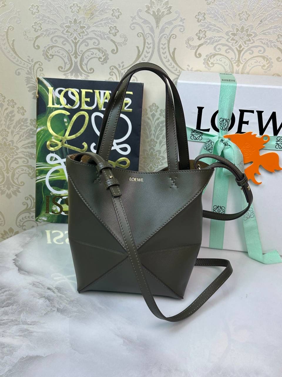 *𝐏𝐮𝐳𝐳𝐥𝐞 𝐅𝐨𝐥𝐝折叠手袋👜* ——全新【𝗡𝗘𝗪】升级‼️ 延续经典𝙋𝙪𝙯𝙯𝙡𝙚的标志性几何裁剪设计，新晋顶流🅰️𝙋𝙪𝙯𝙯𝙡𝙚 𝙁𝙤𝙡𝙚 𝙏𝙤𝙩𝙚以折纸包为灵感，升级成🉑完全折叠‼️的结构，立体与平面任意切换，出差旅行🧳必备单品。小牛皮材质轻且柔软，𝐌𝐢𝐧𝐢尺寸搭配一条可拆卸式肩带，手提，肩背，斜挎多样化背法✨ 尺寸：𝟏𝟔.𝟓-𝟗.𝟓-𝟐𝟎cm 款号：052322