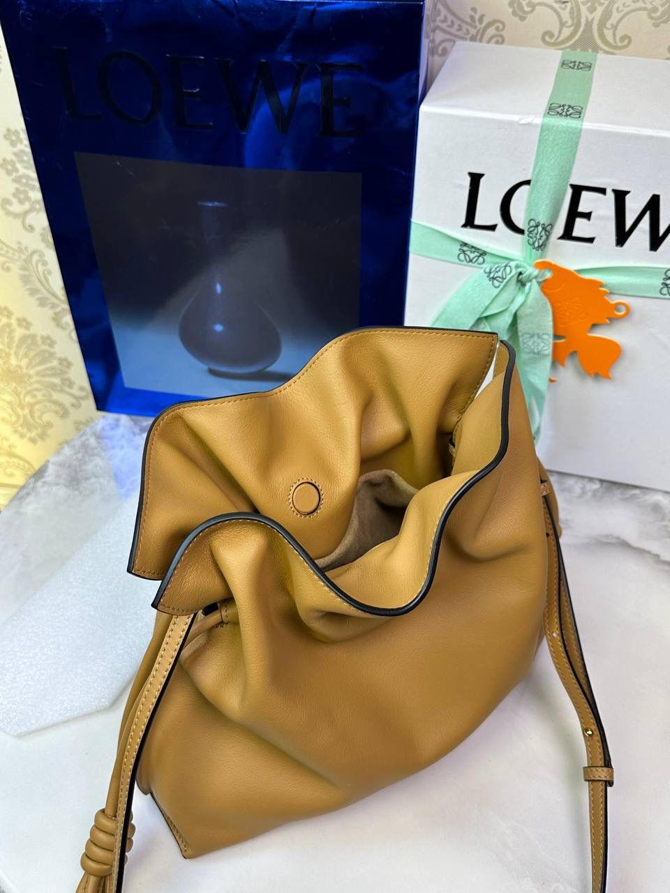 Flamenco clutch✦中号✦ 尺寸：𝟑𝟎-𝟐𝟒.𝟓-𝟏𝟎.𝟓𝐜𝐦 型号：052028 棕色 ❤️flamenco clutch bag可手拿亦可优雅斜挎 云朵般温暖亦轻盈的造型如此简单，💯耐看💯不会out的款式！ ❤️包袋采用进口小牛皮，手感如羊皮般细腻柔软，却比羊皮更加结实耐用，麂皮内衬 ❤️品牌标志性绳结设计，收紧袋口就是小福袋造型，超Q，看着不大实际超会装😇