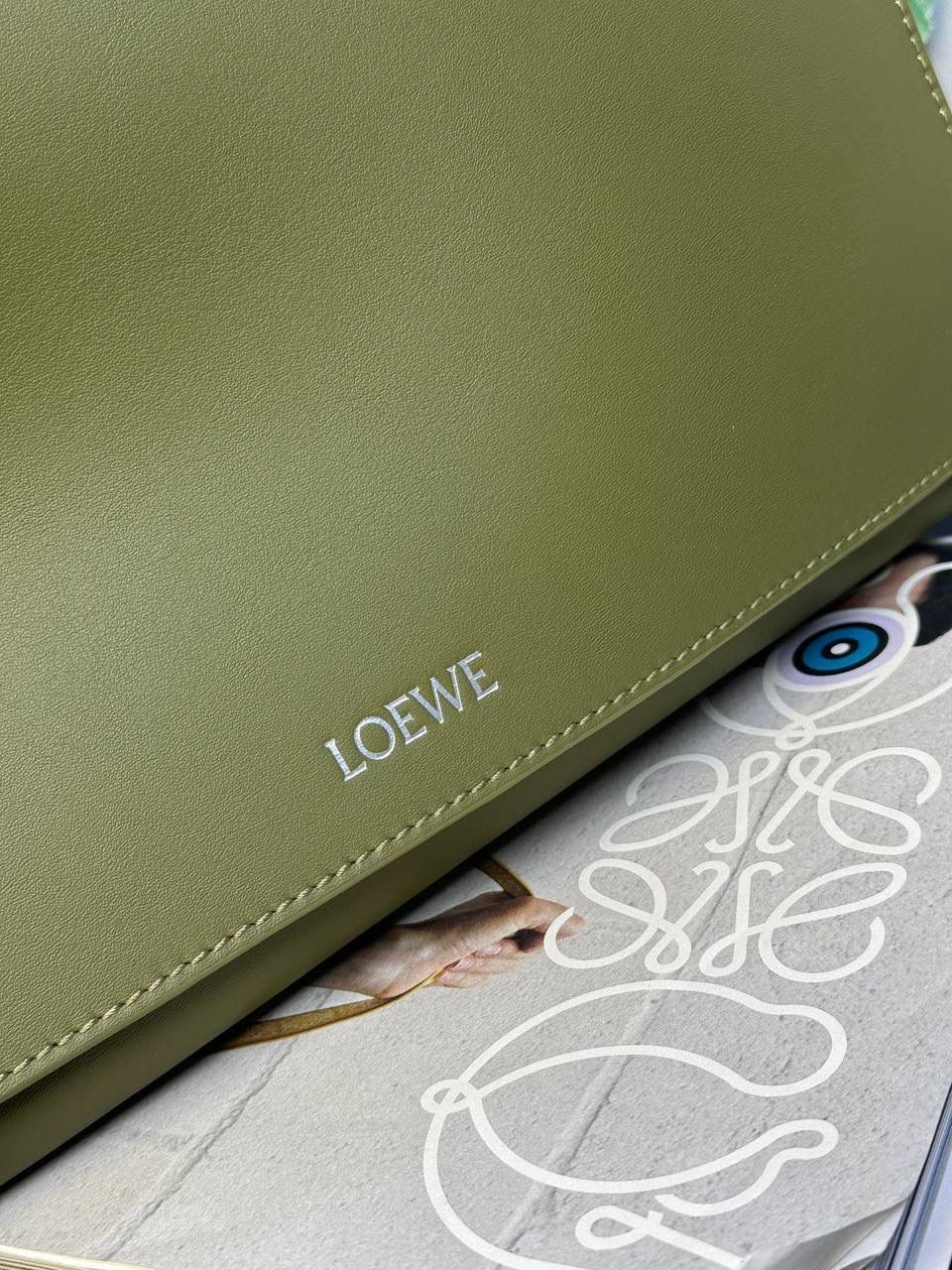 【全皮橄榄色】 𝙇𝙤𝙚𝙬𝙚 𝙁𝙡𝙖𝙢𝙚𝙣𝙘𝙤 𝙎𝙖𝙩𝙘𝙝𝙚𝙡 福袋款邮差包 ➕刺绣🅾️字母宽肩带 编码：062404 尺寸：𝟑𝟒-𝟏𝟐-𝟐𝟒𝐜𝐦 新款以经典福袋收缩打结为元素，采用内部麂皮➕外部进口小牛皮➕刺绣字母宽肩带的精致搭配打造全新升级款邮差包🅰️，可斜挎、肩背和手提，超大容量满足日常所需🎈