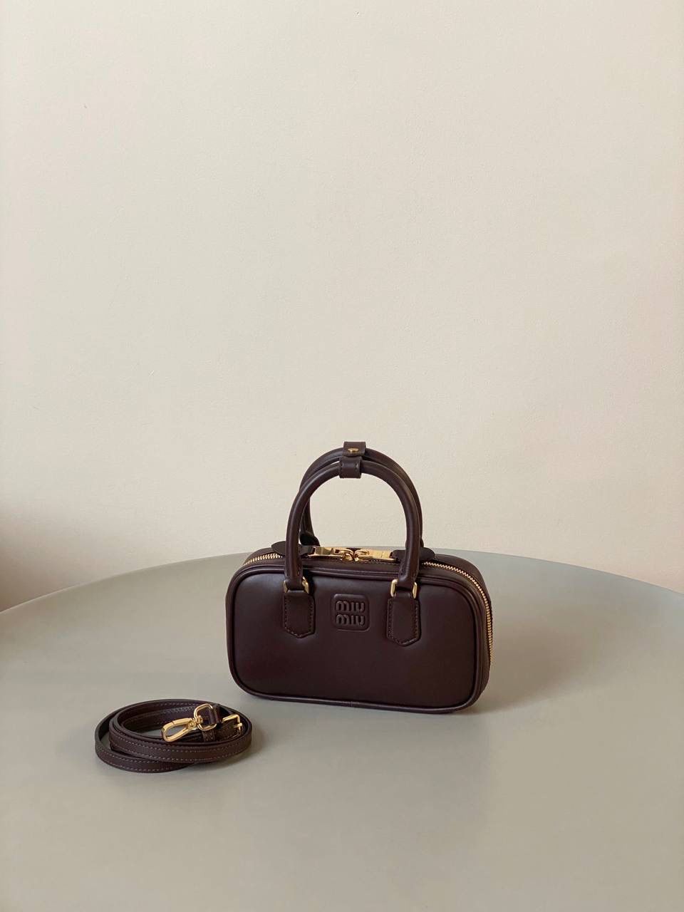 🈶石南木色，迷你 𝗠𝗶𝘂𝗠𝗶𝘂保龄球，大爆款 新尺寸也太可爱了！ 喜欢小包的姐妹这只必买！它要比小号小一些也窄一些 就巴掌大小，但容量还挺大的 装俩部手机都绰绰有余，日常够用 肩带长短也很ok，手拎斜挎都好看 反正放心冲就是了！拥有它，上班牛马的心情都会被治愈～ 迷你：19×10×5cm #F0011m 小号：22x10.5x7.5cm 大号：27x12x9cm