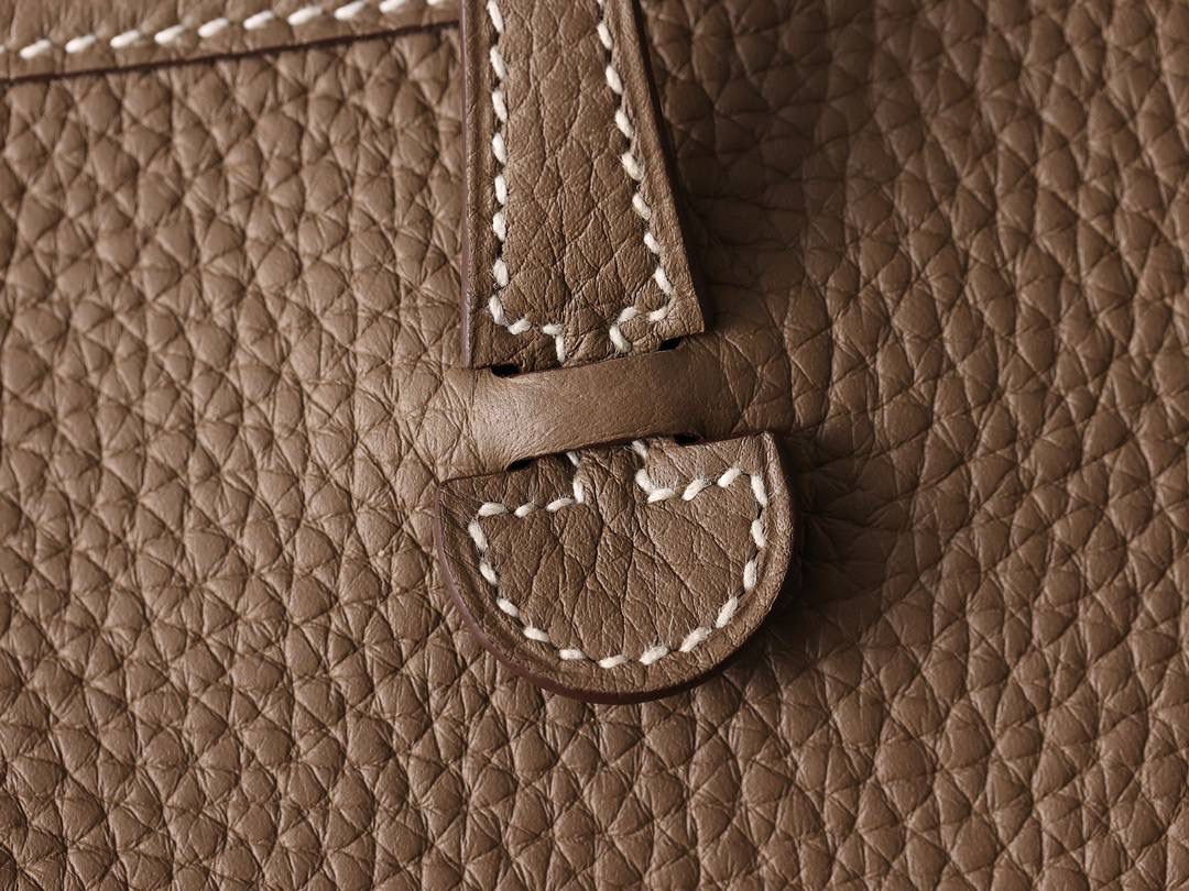 HERMES爱马仕Evelyne 16伊芙琳大象灰金扣👜✨ TaurillonMaurice 小公牛皮 尺寸：16*18*5cm 爱马仕Evelyne伊芙琳 Evelyne包的设计灵感来自于一种名为“马鞍袋”的马具袋，这是一种常用于骑手和马车夫的袋子，用于储存和运输马具和其他必需品。 爱马仕将这种马具袋的经典元素与品牌的手工艺传统相结合，打造出了具有时尚感和功能性的包包。 因此，伊芙琳包不仅是一款实用的手提包，同时也代表着品牌深厚的历史和文化传统❤️