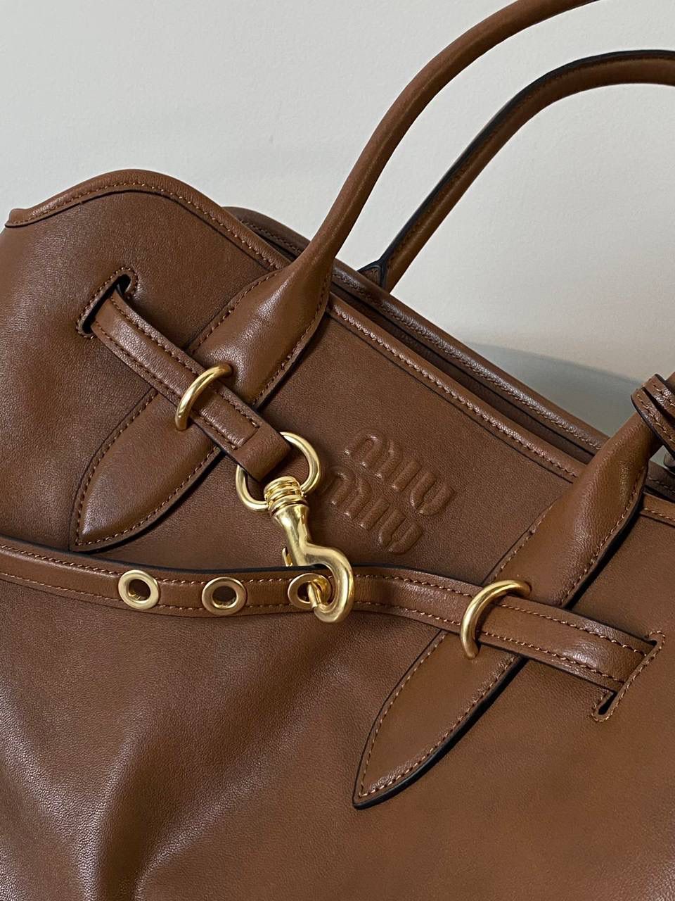 🈶焦糖色， 𝗠𝗶𝘂𝗠𝗶𝘂 手提包 这只Aventure我要夸爆它！ 绝对是公文包中的颜值天花板 这款有多难买不用多说，绝对的断货王 酷酷的慵懒感洋气且时髦 还有一丢vintage感，超有调 上班通勤，日常出街都超出片 很有年轻人的活力！ 31×40×13cm #F0023m