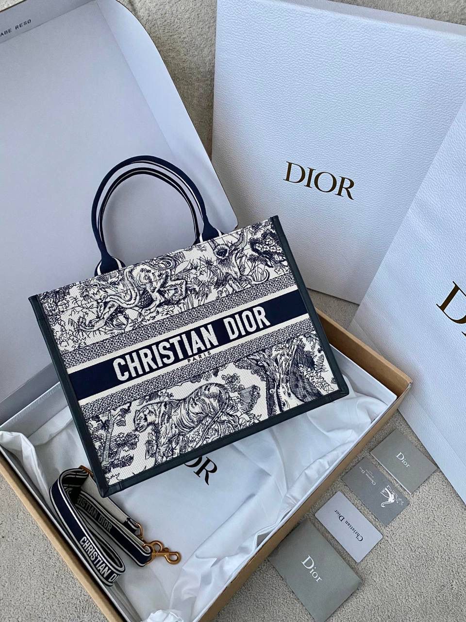 🈶蓝老虎，中号 𝗗𝗜𝗢𝗥 𝗯𝗼𝗼𝗸 𝘁𝗼𝘁𝗲24新版 茹伊印花动物园款它来喽！ 不得不说，D家确实好会玩啊 可以背的托特！简直不要太棒 在最最最经典的托特上又衍生爆款了😍 越来越多人爱背大包真正的无性别之分 不管手拎斜挎，通勤健身出差毫无压力🤟🏻😎 整体有型不会塌，恨不得天天背 大包爱好者可以闭眼收了！！ 36×16×27cm