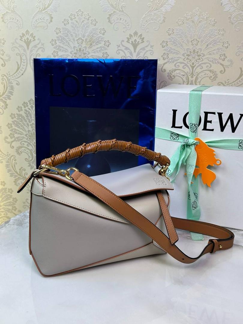 🎈最新编织手腕𝙋𝙪𝙯𝙯𝙡𝙚 ——【灰兰拼色】 尺寸：𝟐𝟒-𝟏𝟎.𝟓-𝟏𝟔.𝟓𝐜𝐦 编码：062405 ♥️以罗家经典几何设计，搭配独特的编织手腕，人字纹里布。 ♥️容量大，经典百搭，可拆卸肩带，有单肩，斜挎，手提等多样化背法。随性时髦洒脱，实用性强。 ♥️独家背景➕独家品质➕独家全套砖柜礼盒套装，市场高端品质皆在我手✌🏻