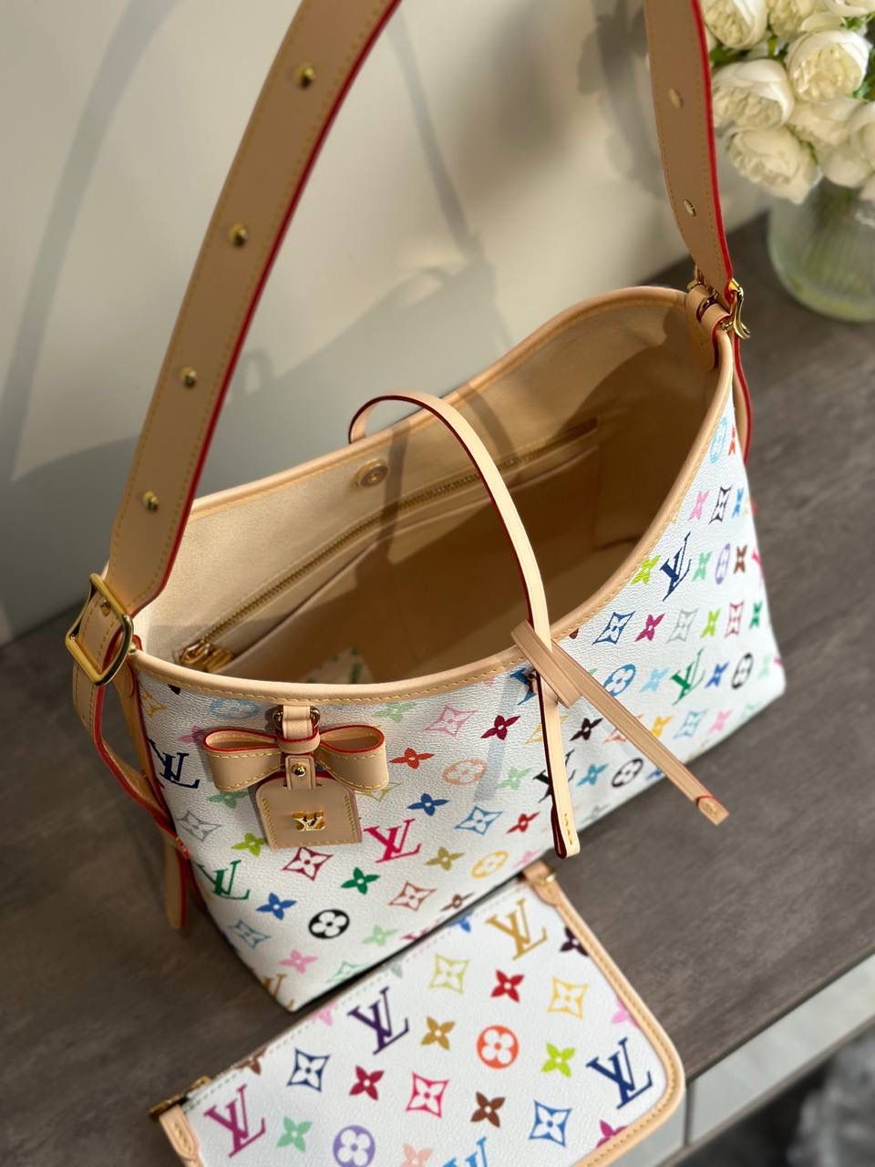 LV 白三彩 Carryall 👜✨ 这是那种—— 一背上街，别人会多看你两眼的包 🌈 白底三彩像把颜色撒进 Monogram 里， 樱花、熊猫跳出来那一刻， 整个包都在发光 ☀️ 不是甜腻，是很有态度的可爱。 Carryall BB 包型软软的、容量却很能装， 通勤不无聊，出游更加分。 蝴蝶结、链条点缀得刚刚好， 甜酷之间拿捏得很准。 如果你已经看腻普通老花， 那这只，就是春天给你的答案 🌸 📏 25 × 31 × 14 cm