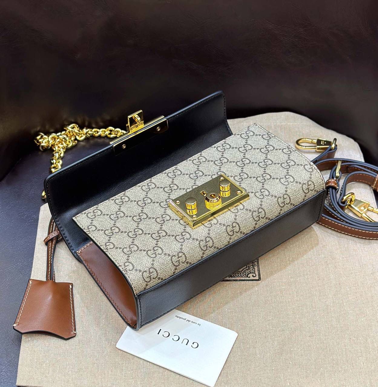 🔥𝐏𝐚𝐝𝐥𝐨𝐜𝐤 月光宝盒# ▫型号：735103 ▫️尺寸：22*11.5*7.5cm 👑经典之王𝙥𝙖𝙙𝙡𝙤𝙘𝙠又出新成员啦，标志性的小锁扣作为主打，保留了原样貌的设计‼️采用原厂黑棕牛皮➕G花面料 三合一的色彩尽显小女人气质的一款包。横版内存空间更大、各自好用、单肩/手挽/斜挎等。钢制耐磨五金，细节都源于正板打造。非常减龄哦！容量也足够日常外出必备小物件！788590