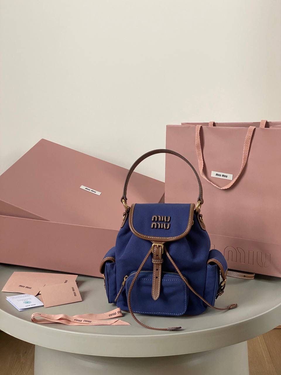 🈶帆布蓝，小号 𝐌𝐢𝐮𝐌𝐢𝐮 双肩包 喔噻！缪缪终于出双肩包了！ 超级经典的款，配色也是无敌了 多个口袋设计非常复古学院风，青春洋溢！ 五金质感超绝，带有微微做旧的复古磨砂感 这种材质耐用度极高 帆布版俩个颜色都好看！海军蓝，甜酷不失高级感 总的来说夏天就是要拿个亮色的出游 轻便实用 小号：18×22×11.5cm #F0060m 大号：25x29x12.5cm