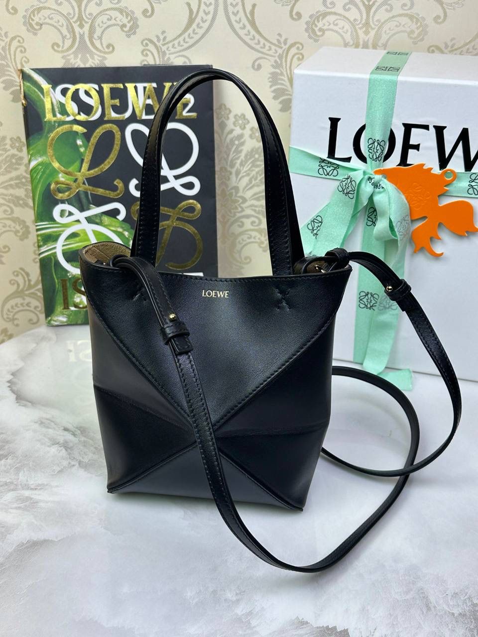 *𝐏𝐮𝐳𝐳𝐥𝐞 𝐅𝐨𝐥𝐝折叠手袋👜* ——全新【𝗡𝗘𝗪】升级‼️ 延续经典𝙋𝙪𝙯𝙯𝙡𝙚的标志性几何裁剪设计，新晋顶流🅰️𝙋𝙪𝙯𝙯𝙡𝙚 𝙁𝙤𝙡𝙚 𝙏𝙤𝙩𝙚以折纸包为灵感，升级成🉑完全折叠‼️的结构，立体与平面任意切换，出差旅行🧳必备单品。小牛皮材质轻且柔软，𝐌𝐢𝐧𝐢尺寸搭配一条可拆卸式肩带，手提，肩背，斜挎多样化背法✨ 尺寸：𝟏𝟔.𝟓-𝟗.𝟓-𝟐𝟎cm 款号：052322