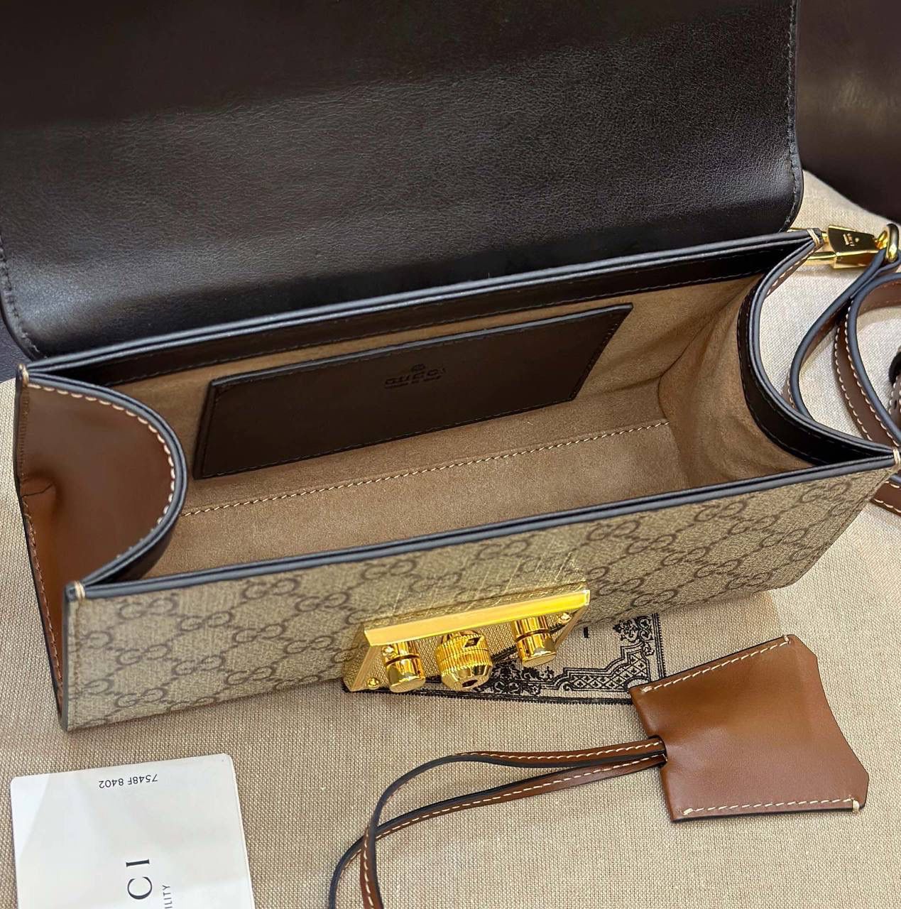 🔥𝐏𝐚𝐝𝐥𝐨𝐜𝐤 月光宝盒# ▫型号：735103 ▫️尺寸：22*11.5*7.5cm 👑经典之王𝙥𝙖𝙙𝙡𝙤𝙘𝙠又出新成员啦，标志性的小锁扣作为主打，保留了原样貌的设计‼️采用原厂黑棕牛皮➕G花面料 三合一的色彩尽显小女人气质的一款包。横版内存空间更大、各自好用、单肩/手挽/斜挎等。钢制耐磨五金，细节都源于正板打造。非常减龄哦！容量也足够日常外出必备小物件！788590