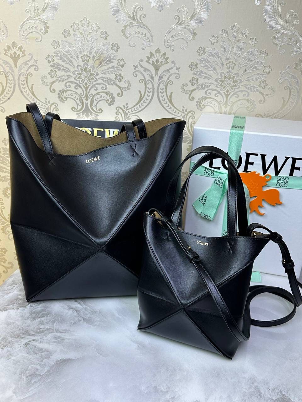 *𝐏𝐮𝐳𝐳𝐥𝐞 𝐅𝐨𝐥𝐝折叠手袋👜* ——全新【𝗡𝗘𝗪】升级‼️ 延续经典𝙋𝙪𝙯𝙯𝙡𝙚的标志性几何裁剪设计，新晋顶流🅰️𝙋𝙪𝙯𝙯𝙡𝙚 𝙁𝙤𝙡𝙚 𝙏𝙤𝙩𝙚以折纸包为灵感，升级成🉑完全折叠‼️的结构，立体与平面任意切换，出差旅行🧳必备单品。小牛皮材质轻且柔软，𝐌𝐢𝐧𝐢尺寸搭配一条可拆卸式肩带，手提，肩背，斜挎多样化背法✨ 尺寸：𝟏𝟔.𝟓-𝟗.𝟓-𝟐𝟎cm 款号：052322