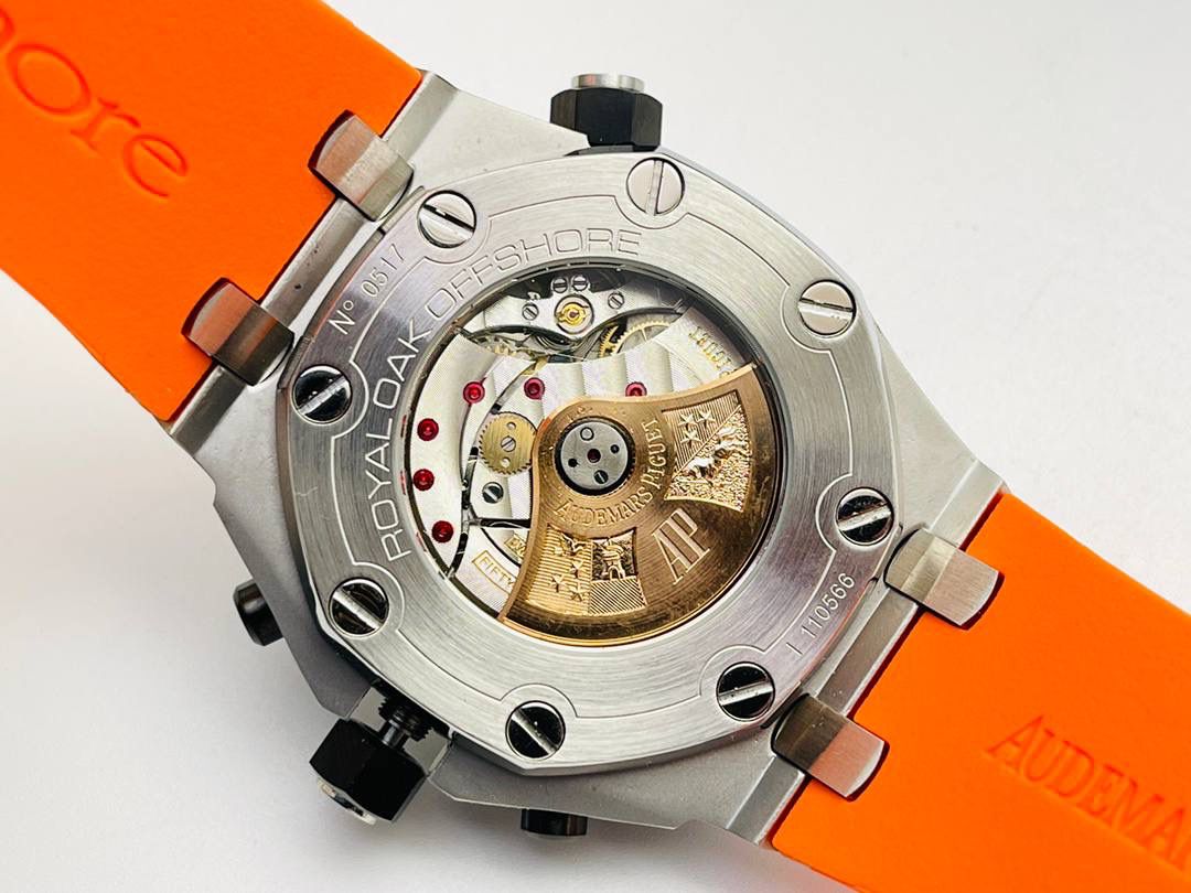 爱彼A P皇家橡树系列水果腕表！ 型号：26703 跑秒计时自动机械男表！搭载原版cal.3124机芯 直径：42MM！ 1⃣️表壳材质选用的904L精钢，经过CNC一次成型锻造了42MM的表径，表壳在经过拉丝工艺多次打磨抛光后做到了无懈可击，包括螺钉也一致还原！ 2⃣️表盘字面格纹错落有致，立体感很强。刻度线粗细程度以及长短均与正品保持一致。条钉时标内部填充超强夜光材料。两组小圆盘对称分布，就像两只小眼睛。盘面内有一圈一圈的放大环，细节处理很到位。 3⃣️橡胶表带表面的磨砂质感很强.采用无味不沾灰尘的进口橡胶，只为提高佩戴的舒适感！ 4⃣️前后玻璃都采用蓝宝石水晶镜面玻璃，镜面通透性也很强。这款腕表采用3124机芯，做到了外观和正品的极其相似，走时精准稳定！