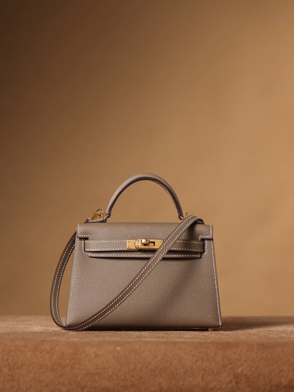 HERMES 爱马仕 Mini Kelly 二代 👜✨ Mini Kelly 二代 大象灰金扣 高清实拍图 尺寸：19*12*6cm Hermès爱马仕是世界著名的奢侈品品牌，1837年由Thierry Hermès创立于法国巴黎。爱马仕早年以制造高级马具起家，迄今已有180年的悠久历史。 其整个品牌从整体到细节以及专卖店，都弥漫着浓郁的以马文化为中心的深厚底蕴🎀