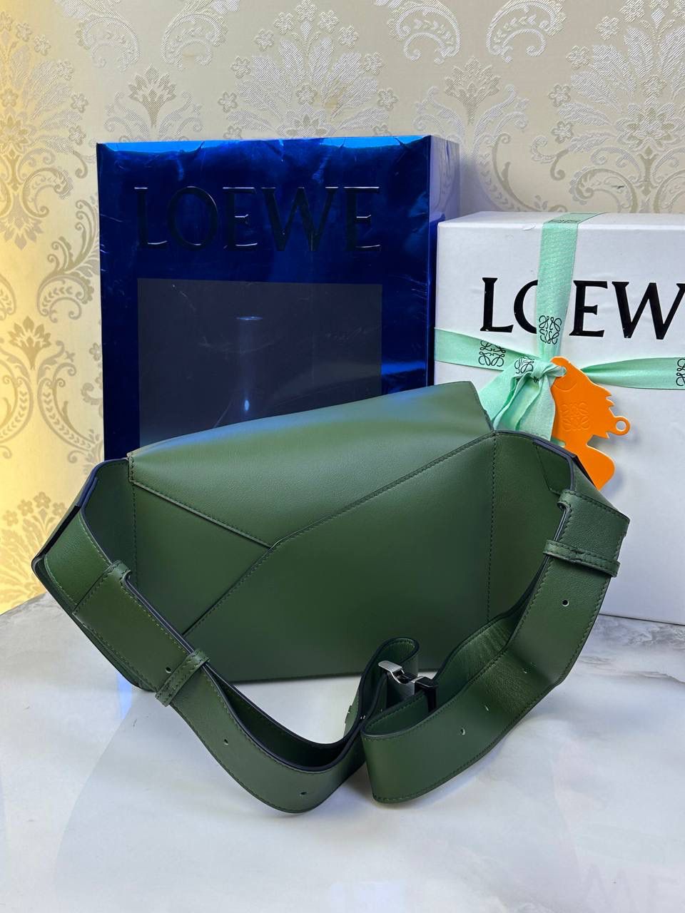 ⭐️最新升级版𝟮.𝟬-𝗣𝘂𝘇𝘇𝗹𝗲腰包⭐️ （森林绿🌳到货‼️） 尺寸：𝟮𝟰-𝟭𝟬.𝟱-𝟭𝟲𝗰𝗺 款号：052343 👉🏻长方体形状和精确的切割技巧创造出Puzzle 腰包以及独特的几何线条成为 “Loe罗家”的著名代表作~ 👉🏻金属搭扣开合，刻有标志logo徽标，可调节肩带，翻盖大容量插袋和一个外部拉链口袋，🐂柔软细腻napa小牛皮，正品Ykk五金，Anagram压纹，人字纹棉麻帆布内里 👉🏻（男女♀♂同款）大小非常合适。胸包、背包、单肩、斜挎 腰包五种背法任你解锁🔒 👉🏻 （独家背景➕独家品质➕独家包装➕独家控制对版细节📦➕精致全套礼盒套装❤️） 重点：让你花最少的钱💰体验最大的仪式感❤️