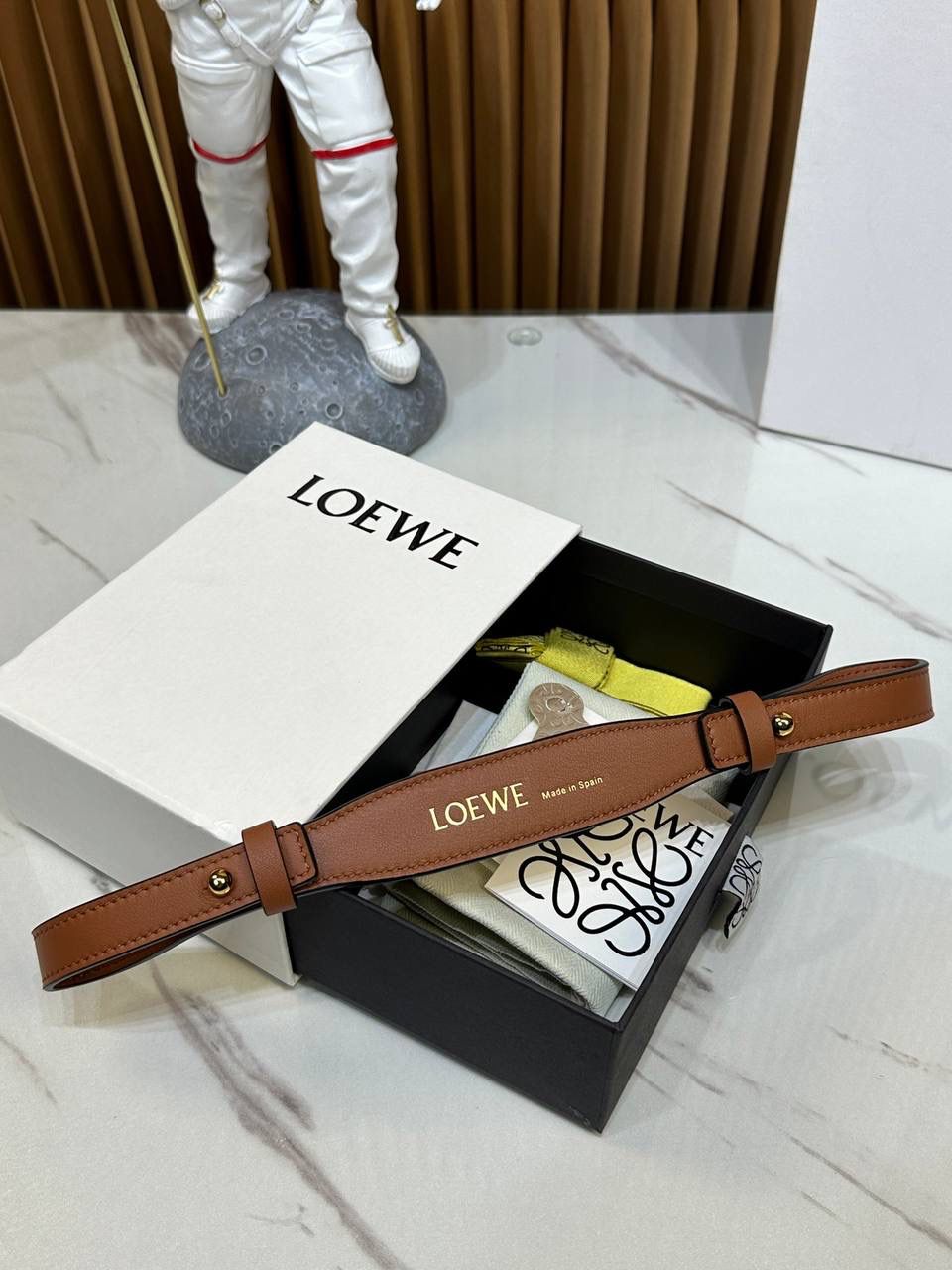 ★𝙇𝙤𝙚𝙬𝙚单配短肩带★棕色 ✅经典小牛皮制作，进口沙菲线，全铜五金。 ✅正面饰以品牌标志性烫金𝙇𝙊𝙂𝙊字体，两侧金属扣固定，🉑️做手提包使用的百搭肩带。 尺寸：55.5-2cm 编码：182323