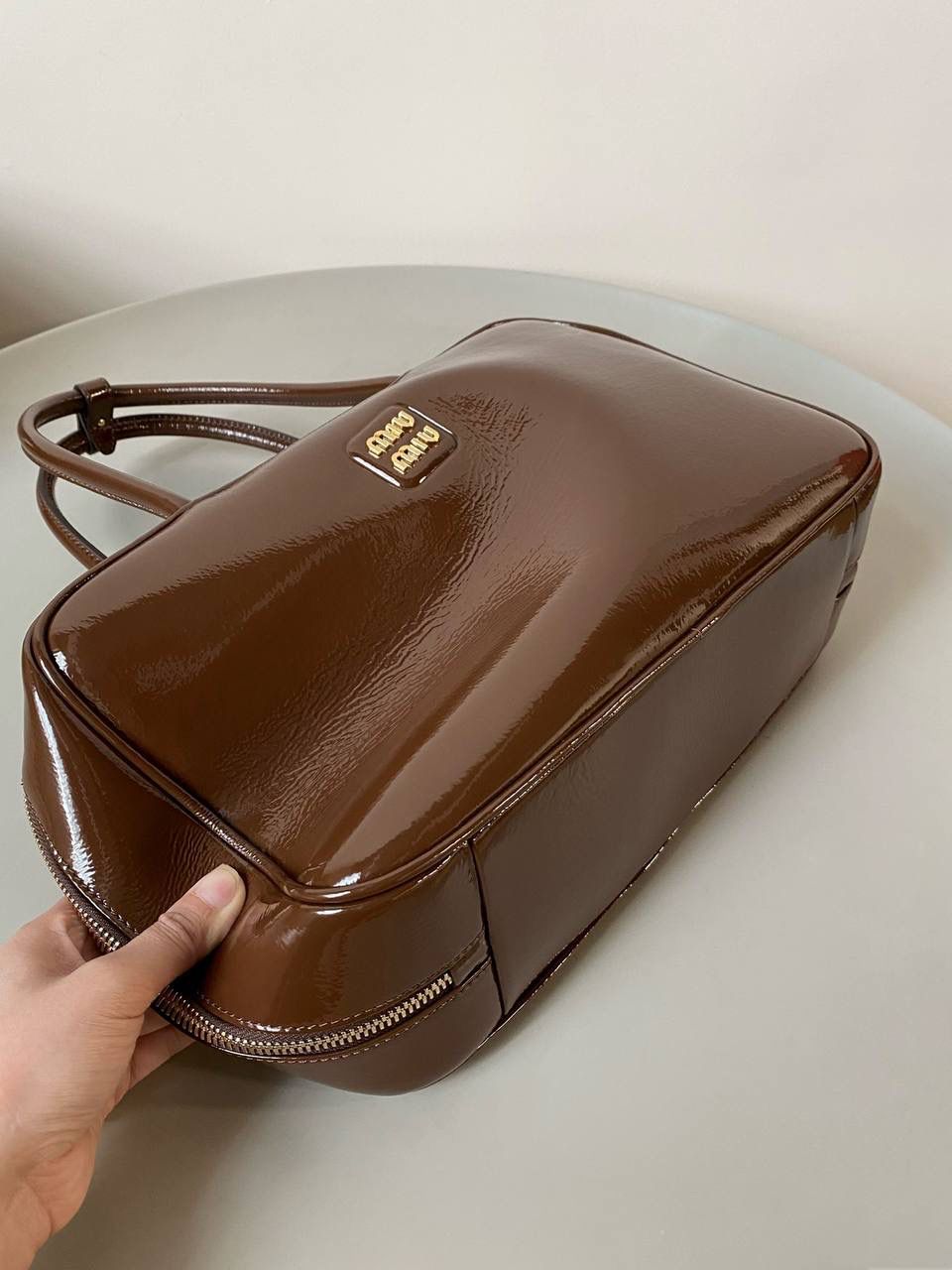 🈶漆皮紫檀木色 𝗠𝗶𝘂𝗠𝗶𝘂公文包| 新面料来啦 漆皮色泽光亮自然饱满～ 皮面透着的皱纹仿佛湖面上的水波纹 无论是视觉还是手感，质感都很绝！ 34×23×10cm #F0020m