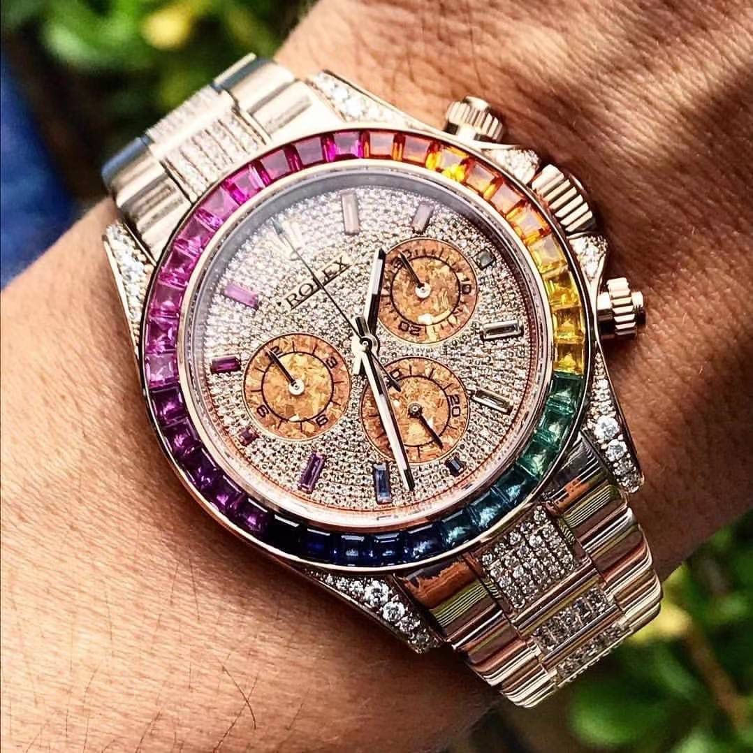 飞越彩虹之巅---劳家彩虹圈迪通拿 铂金眼 Cal.7750机械计时， “二代彩虹迪通拿”表壳、表带采用316L精钢材质打磨，每个壳套全程CNC处理所有细节，再经过人工流程润饰，打磨和检测做工精细，圈口角度与宝石大小数量颜色跟专柜彩虹渐变效果一致，玻璃使用蓝宝石透彻效果镜面，机芯采用7750全自动计时机械机芯，表带分别全人工镶钻精钢实心表带OR进口氟橡胶表带，配备防止意外打开的蚝式保险扣，佩戴舒适，操作也十分简便！ 这款腕表最大的特点莫过于表圈的七彩宝石和字面的十二个彩钻刻度，彩色渐变效果一一对应，这些宝石闪耀着红橙黄绿青蓝紫等斑斓的色彩，恰似添上曼妙多姿的变化色彩，劳力士精心挑选了玲珑精巧的宝石，并组合镶嵌在了一起，为腕表赋予了奇异的光彩。