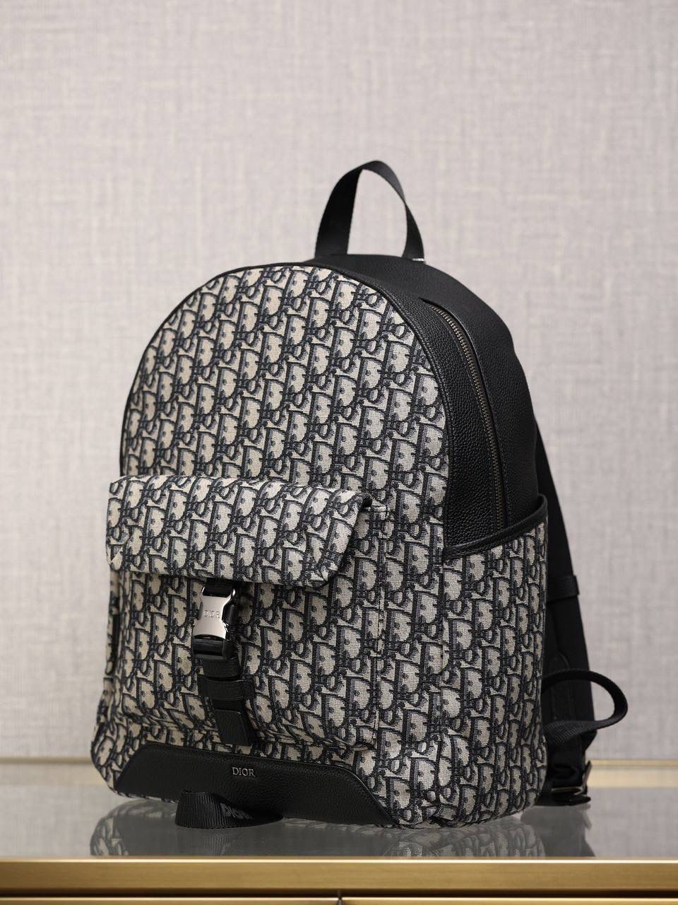 DIOR EXPLORER 双肩背包👜💕 米色和黑色 Oblique 印花 采用米色和黑色提花面料精心制作，饰以 Oblique 印花和黑色粒面牛皮革，侧面“DIOR”皮革补丁别具一格。 宽大的主隔层，搭配带有铝扣的加垫正面翻盖口袋和两个侧面口袋，更显精致。 搭配加垫肩带和金属环，便于悬挂钥匙或 D-Touch 手拿包，可与各式休闲单品搭配，作为造型的点睛之笔。 尺码信息尺寸：30 x 42 x 14.5 厘米 主隔层可收纳 15 英寸笔记本电脑、文件和平板电脑 侧面口袋可收纳一部 iPhone 13 Pro Max 手机