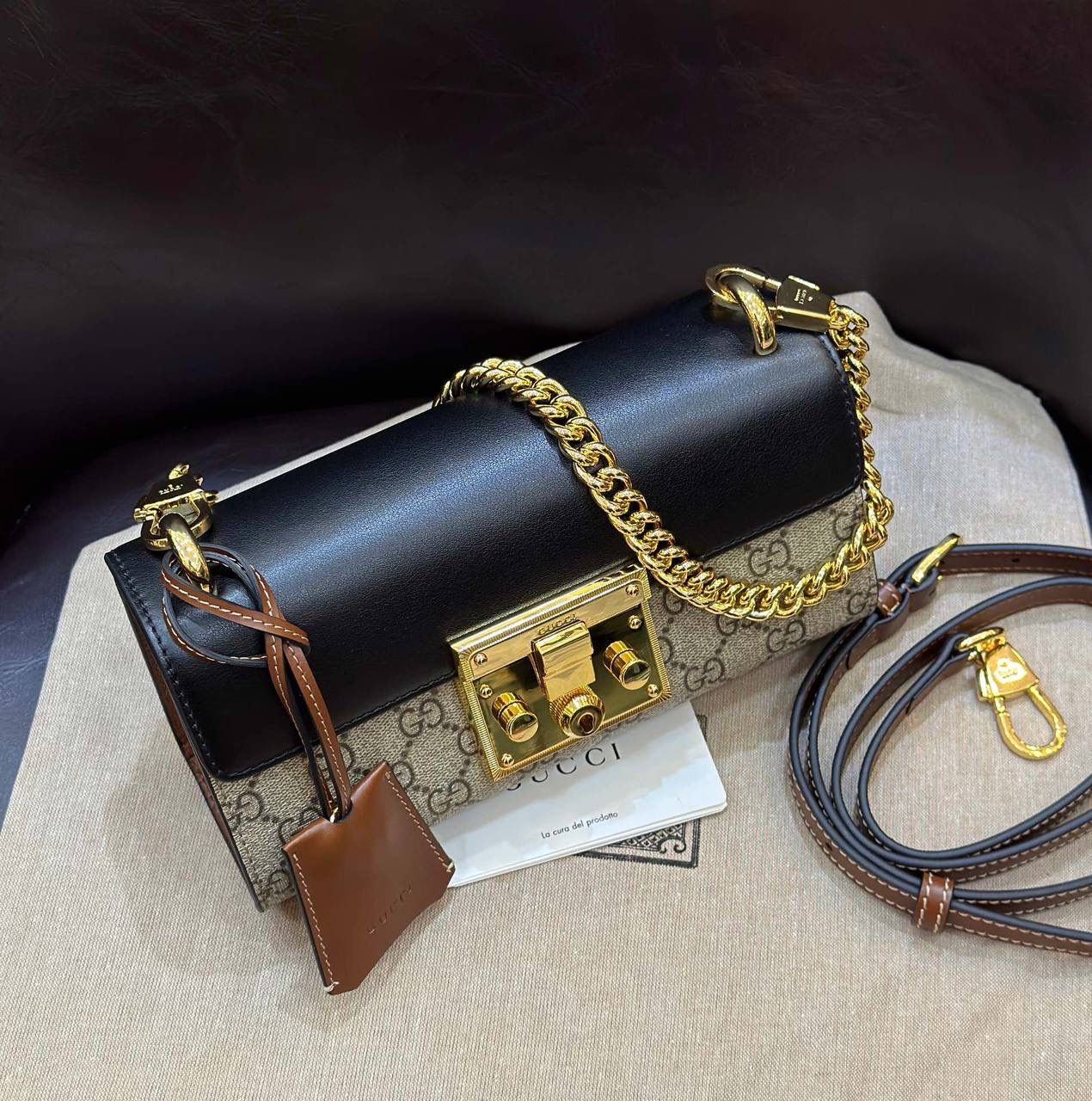 🔥𝐏𝐚𝐝𝐥𝐨𝐜𝐤 月光宝盒# ▫型号：735103 ▫️尺寸：22*11.5*7.5cm 👑经典之王𝙥𝙖𝙙𝙡𝙤𝙘𝙠又出新成员啦，标志性的小锁扣作为主打，保留了原样貌的设计‼️采用原厂黑棕牛皮➕G花面料 三合一的色彩尽显小女人气质的一款包。横版内存空间更大、各自好用、单肩/手挽/斜挎等。钢制耐磨五金，细节都源于正板打造。非常减龄哦！容量也足够日常外出必备小物件！788590