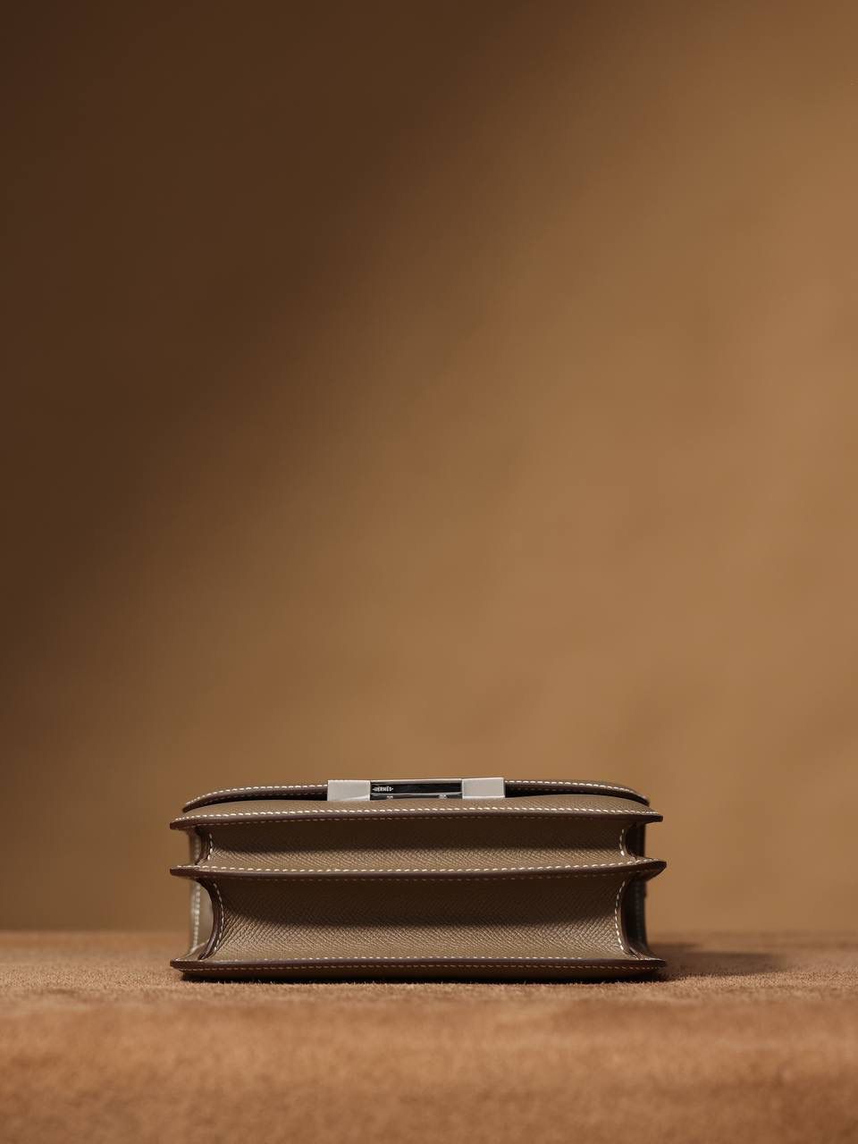 Hermes 爱马仕 #Constance 19大象灰 银扣👜✨ Epsom牛皮 单肩斜挎包 尺寸：19*15*4 cm 这款采用的是Epsom牛皮,纯原皮，和专柜用的是一个渠道的真皮 什么是Epsom牛皮？ 皮质：ep皮/手掌纹、一岁以上的公牛皮 软硬度：偏硬 纹理：皮面颗粒小的细腻皮纹，有点光泽感 特点：硬朗有细纹的牛皮皮质。细纹是进过后期处理的，比较硬质立体，长期贮存也不容易变形。自重轻，不易刮伤，非常耐磨实用。 所以每个H的款式用的皮都不一样，都是非常有讲究的✅